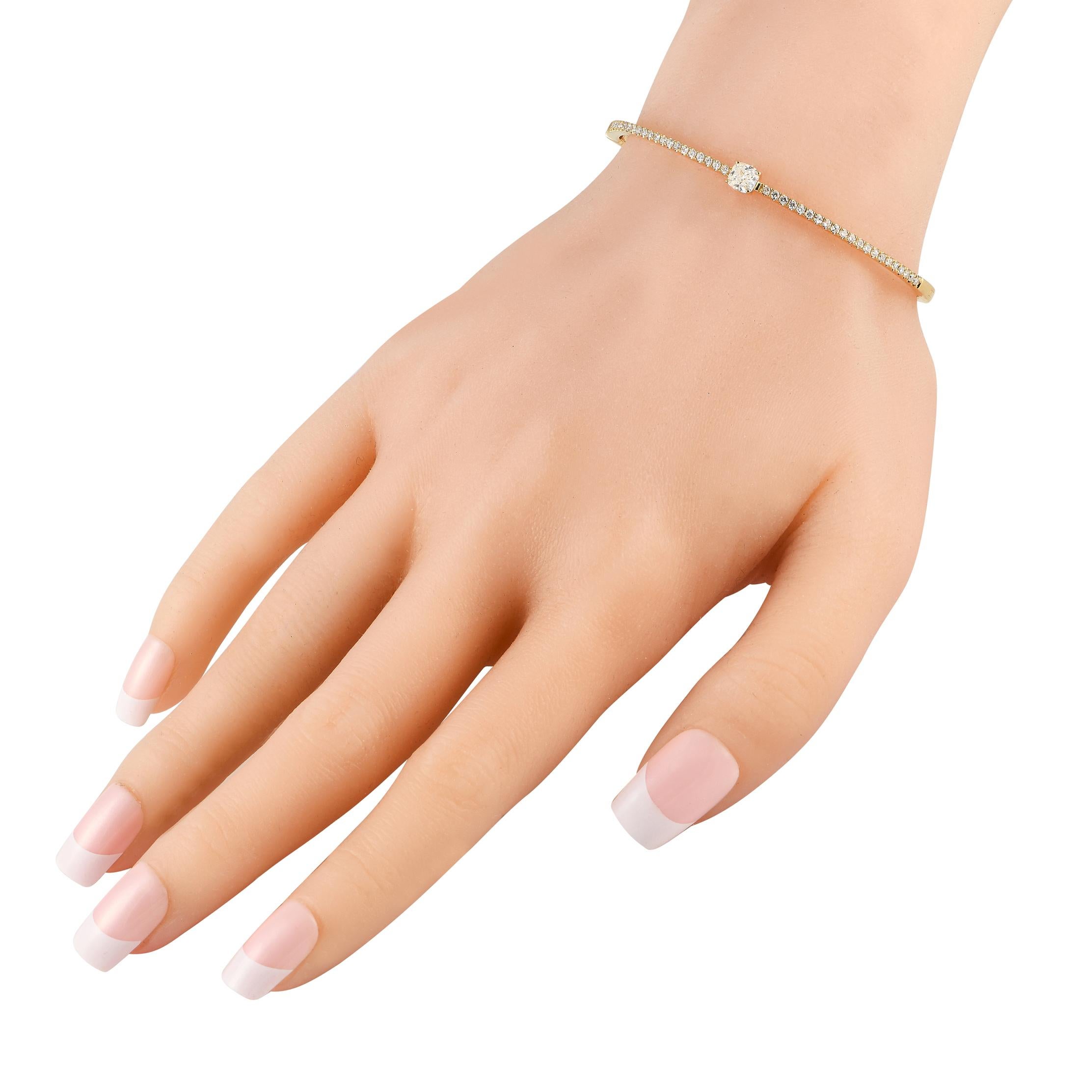 Add a touch of elegance to your wardrobe with this easy-to-wear and easy-to-pair diamond bracelet. Crafted with a slim 18K yellow gold bangle and a box tab clasp, this bracelet is perfect for any occasion. Half of the bangle's circumference is
