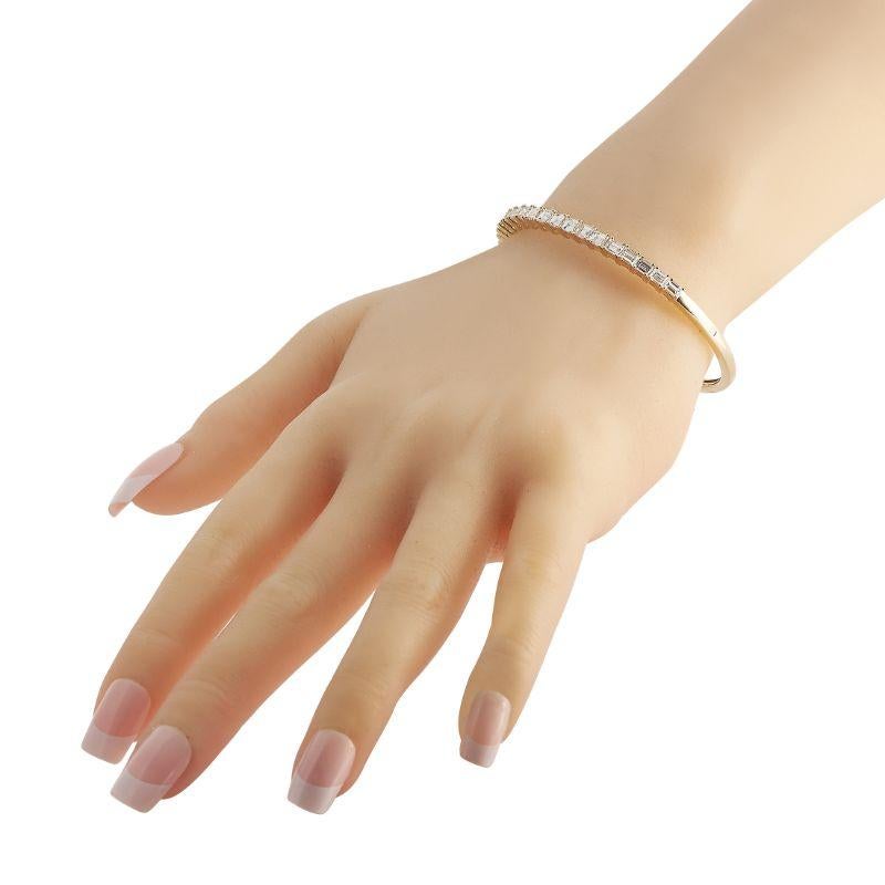 Give any outfit a subtle hint of upscale elegance through this yellow gold diamond bracelet. It features half a circle of diamonds that deliver an understated sparkle. The hinged bangle measures 7 inches and has a box tab clasp. 
 
 Offered in brand