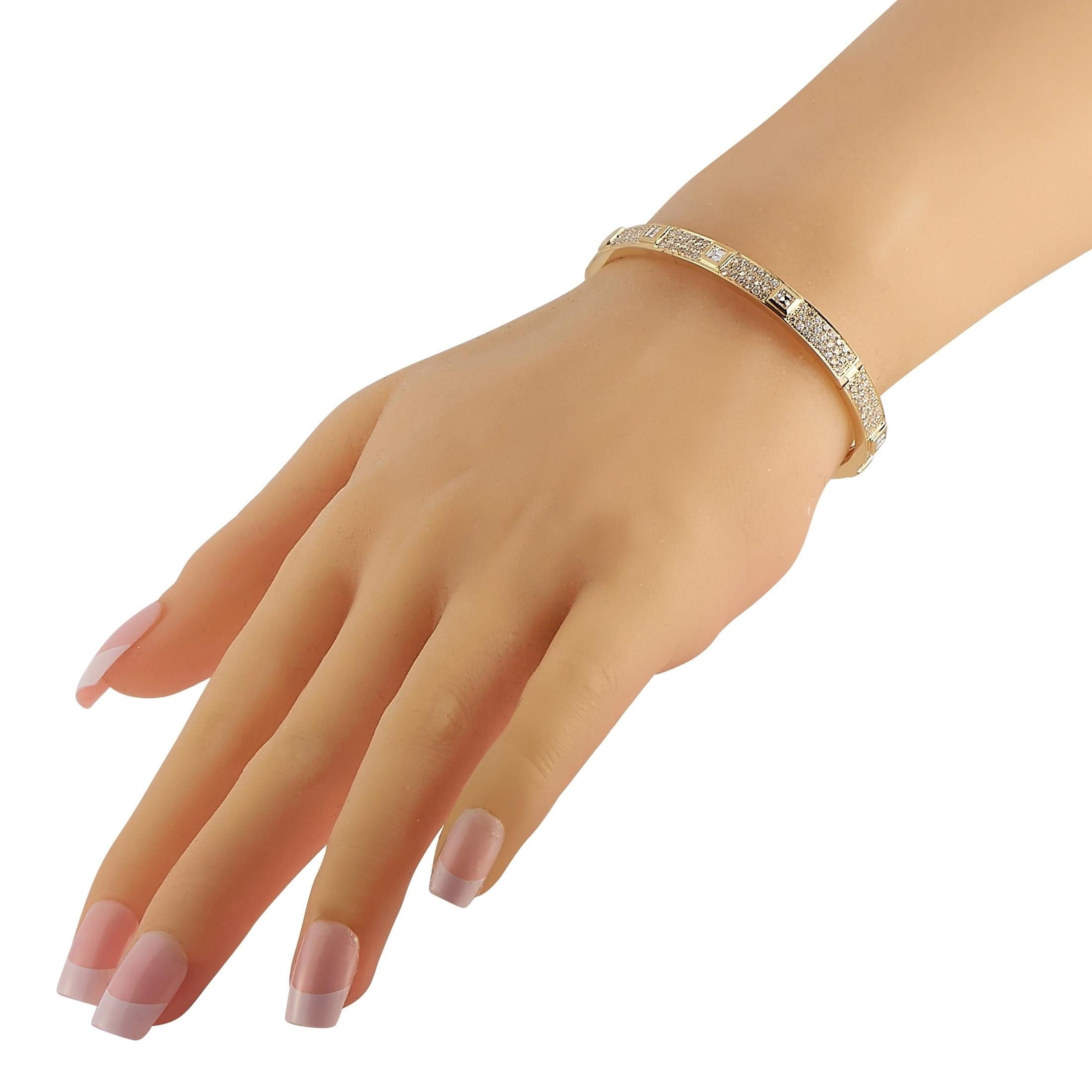  An opulent 18K Yellow Gold setting makes this bangle bracelet incredibly chic. Its stylish geometric design is only elevated by 2.78 carats of round-cut diamonds and Ascher-cut diamonds with a total weight of 1.87 carats. This classic piece