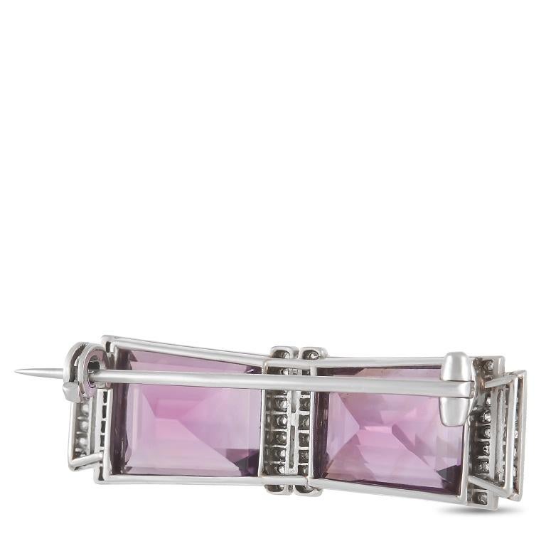 This classy LB Exclusive brooch adds a classic touch to any ensemble. The symmetrical setting is made from platinum and set with rows of round diamonds on either side of two larger amethyst stones. The brooch measures 0.38” in length and 1.38” in
