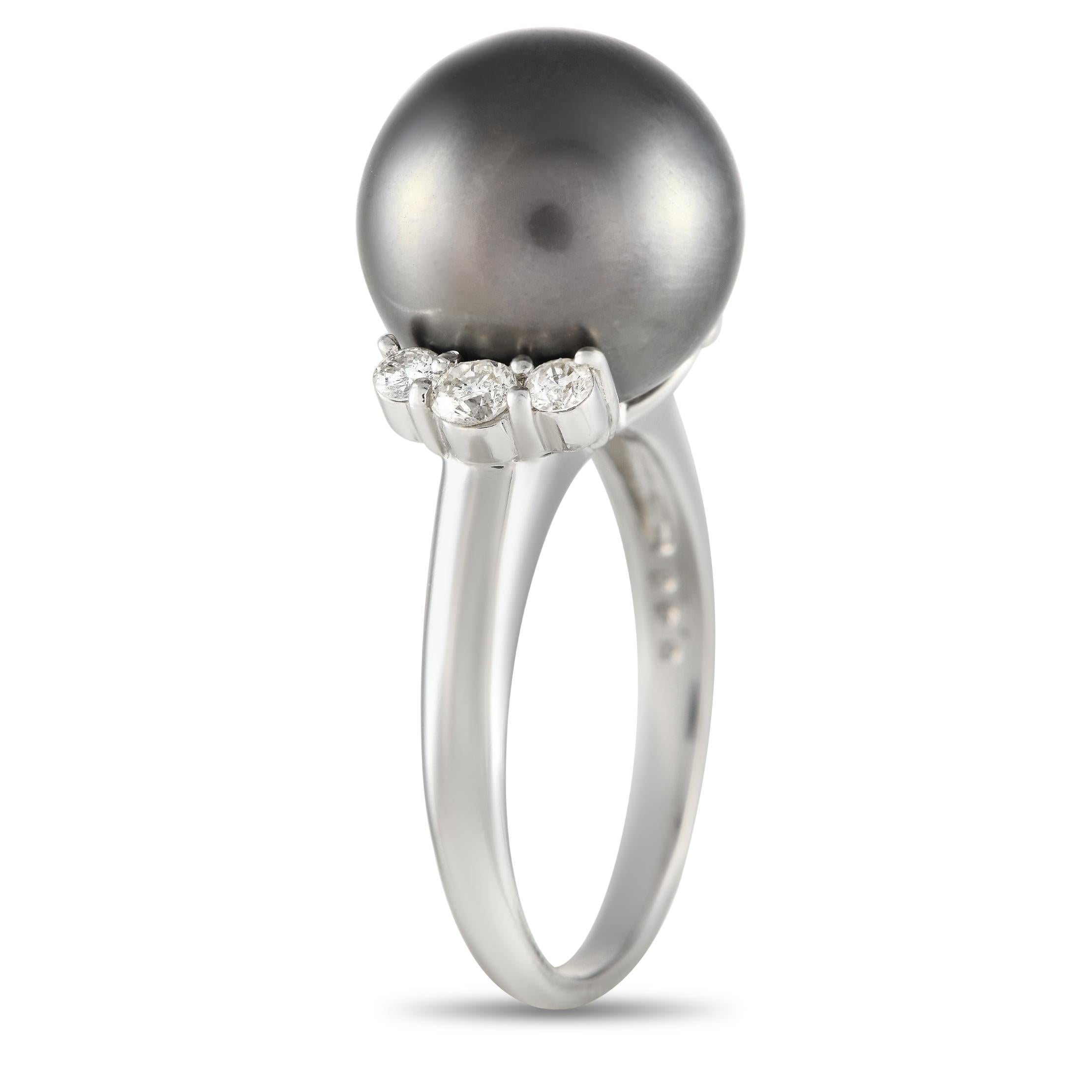 How incredibly majestic is this black pearl ring? It features a polished platinum band topped with a lustrous 11mm black pearl. A trio of diamonds sits on each side of the band, providing support for the imposing central gem. The ring's top