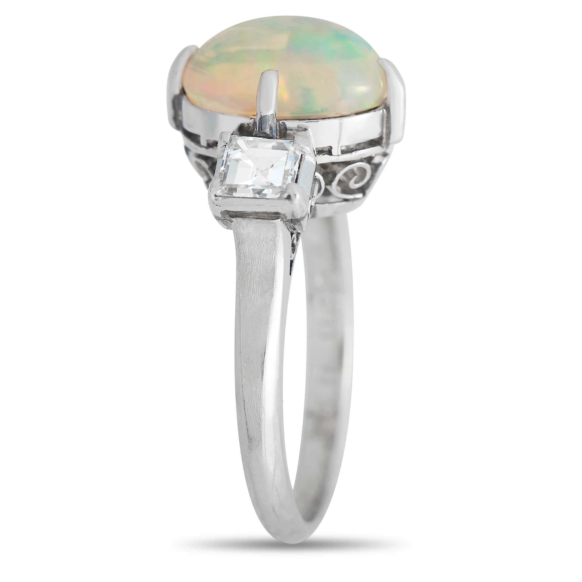 A colorful 1.90 carat Opal gemstone makes a statement at the center of this fabulous ring. A pair of square-cut diamonds totaling 0.49 carats add extra sparkle to this exquisite piece, which features a Platinum setting with a 2mm wide band and a 9mm