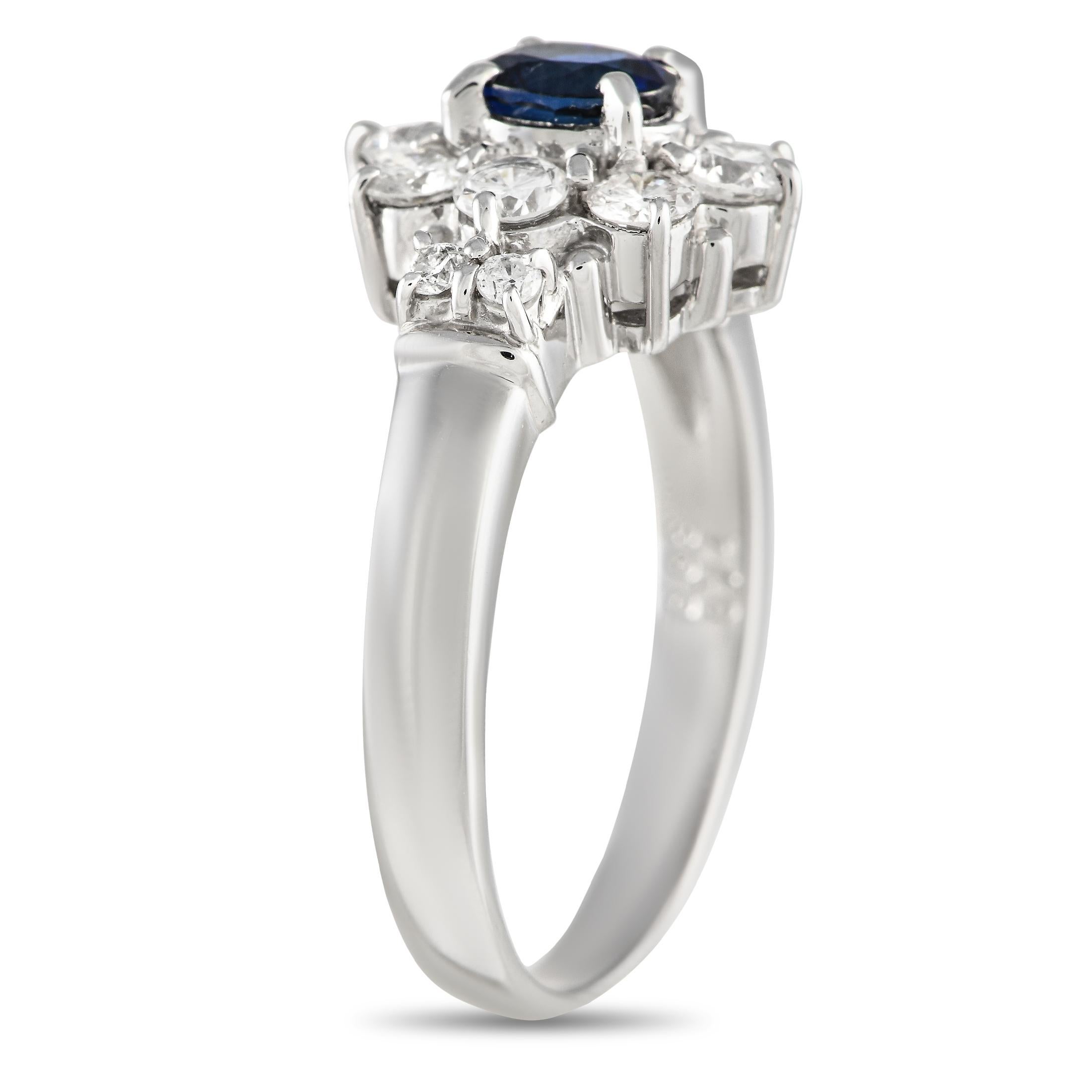 A sleek Platinum setting allows an array of sparkling gemstones to take center stage on this elegant ring. At the center, a 0.63 carat Sapphire makes a statement thanks to a halo of Diamonds with a total weight of 0.74 carats. This piece features a