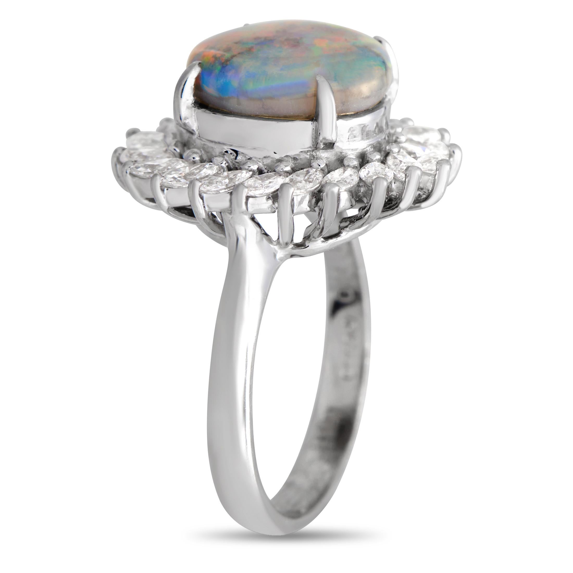 Looking for an effortless way to add a chic and luxurious touch to your looks? Wear this vintage diamond and opal ring. The ring is designed in Art Deco style, with an iridescent opal cabochon surrounded by a sunburst halo of marquise diamonds. The