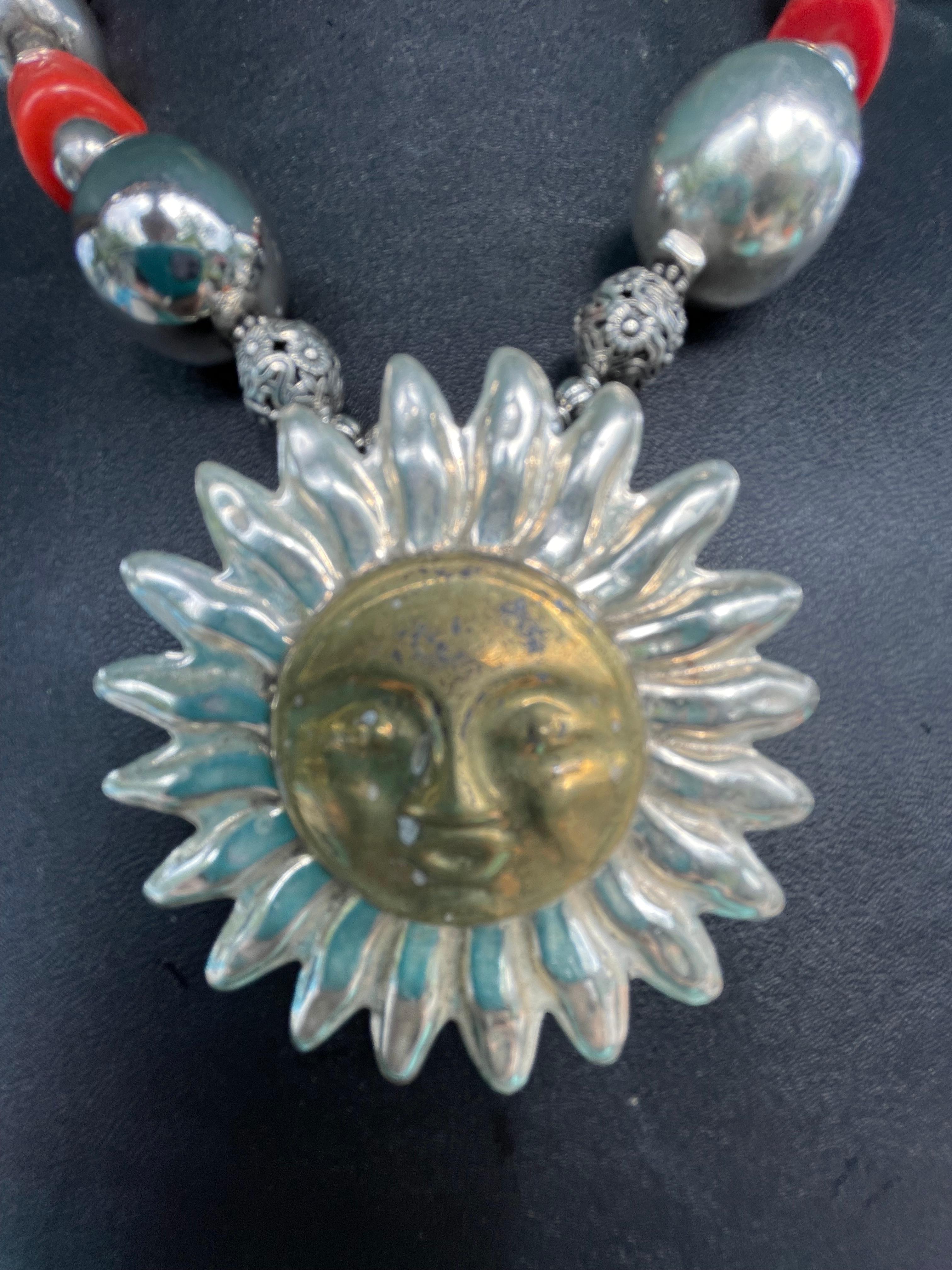 Lorraine’s Bijoux offers a stunning necklace with a large Mexican Sterling and Brass Sun Pendant as its center. This amazing necklace consists of Chinese coral, Italian coral, and vintage Mexican Sterling Silver highly polished beads.The handmade