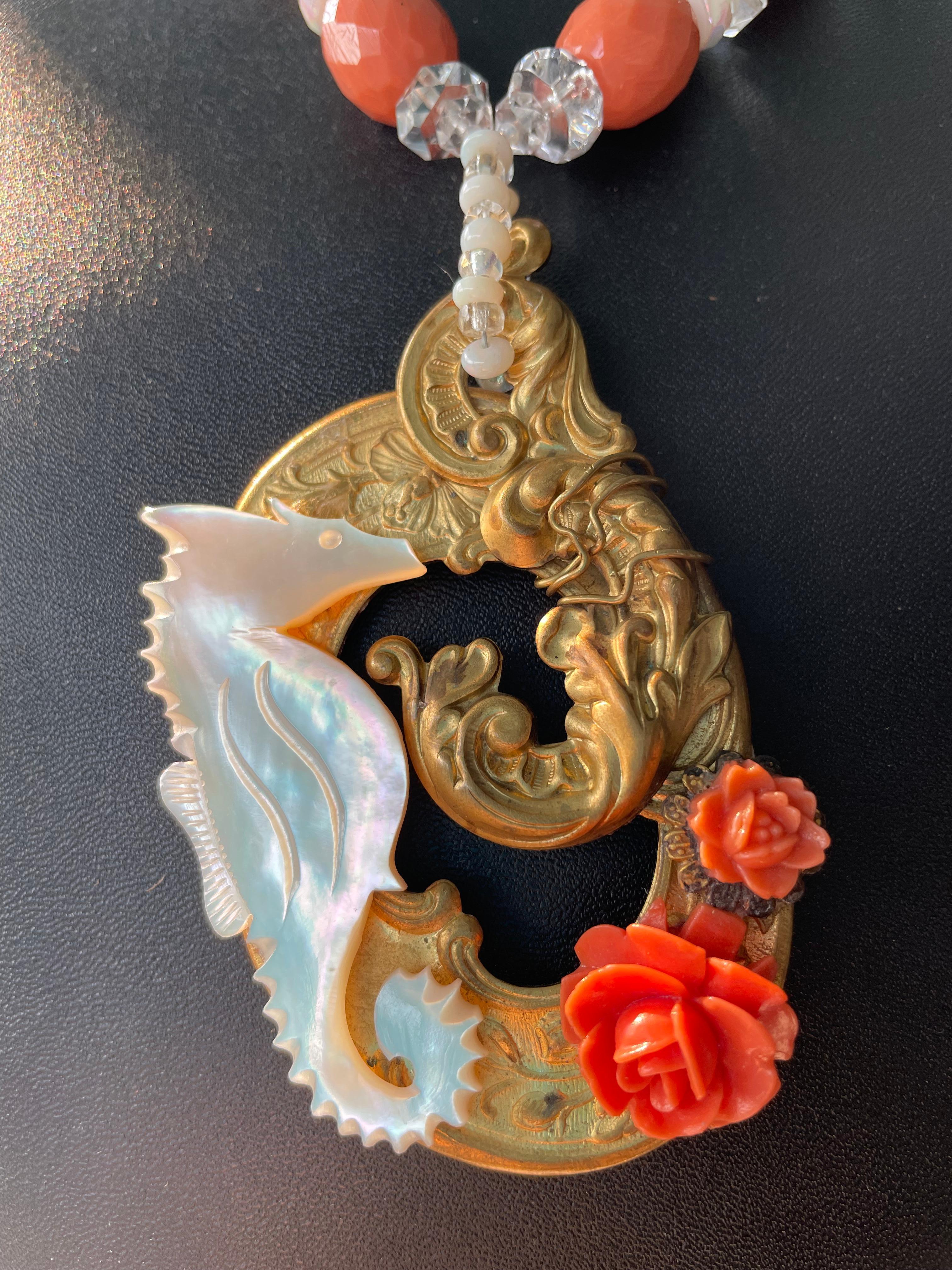 LB original handmade design necklace with multi vintage elements comprising the highly unusual pendant. A vintage brass Rococo style buckle has been embellished with Bakelite roses and a hand carved Mother of Pearl seahorse. Vintage clear and milky