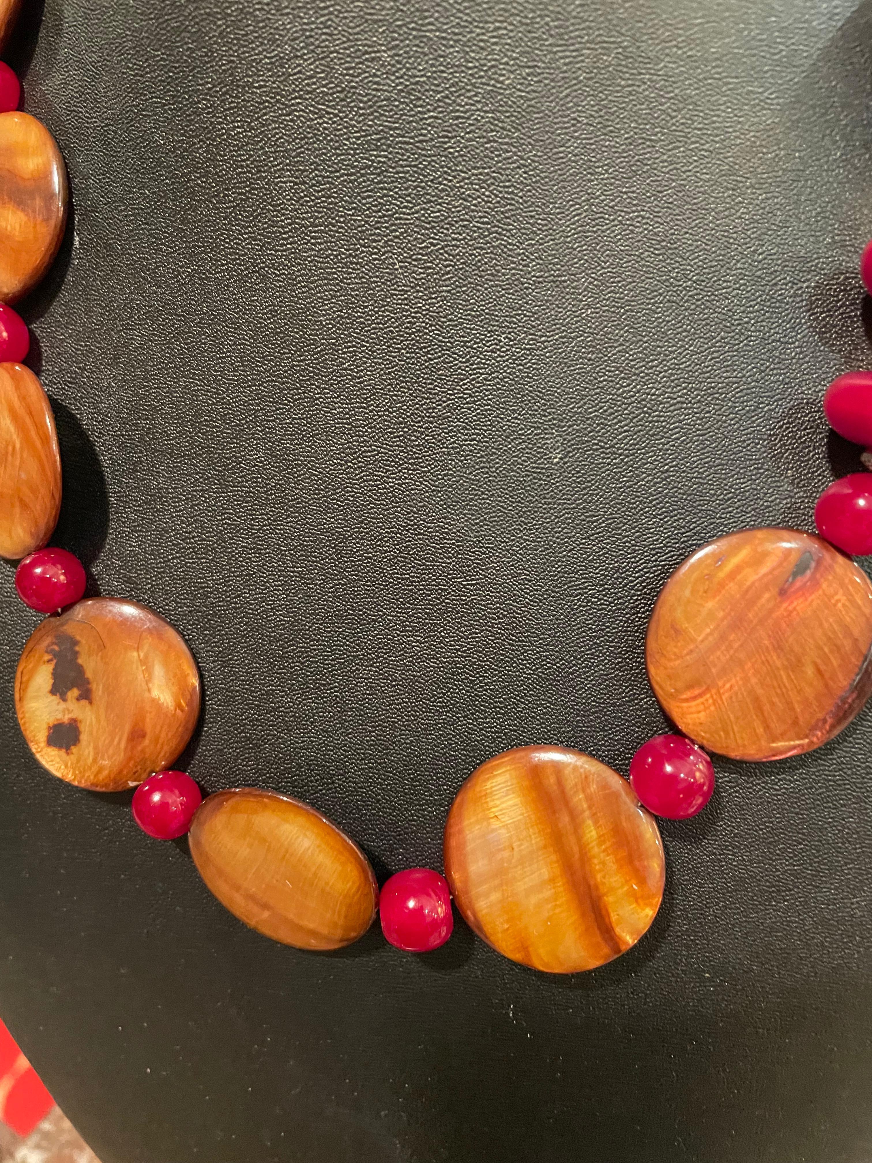 Lorraine’s Bijoux offers a handmade, one of a kind, Indian Resin and Shell necklace. The colors of burgundy resin and gold shell are rich and flattering to every complexion. This piece has a wonderful chunkiness and loads of drama. The round shell
