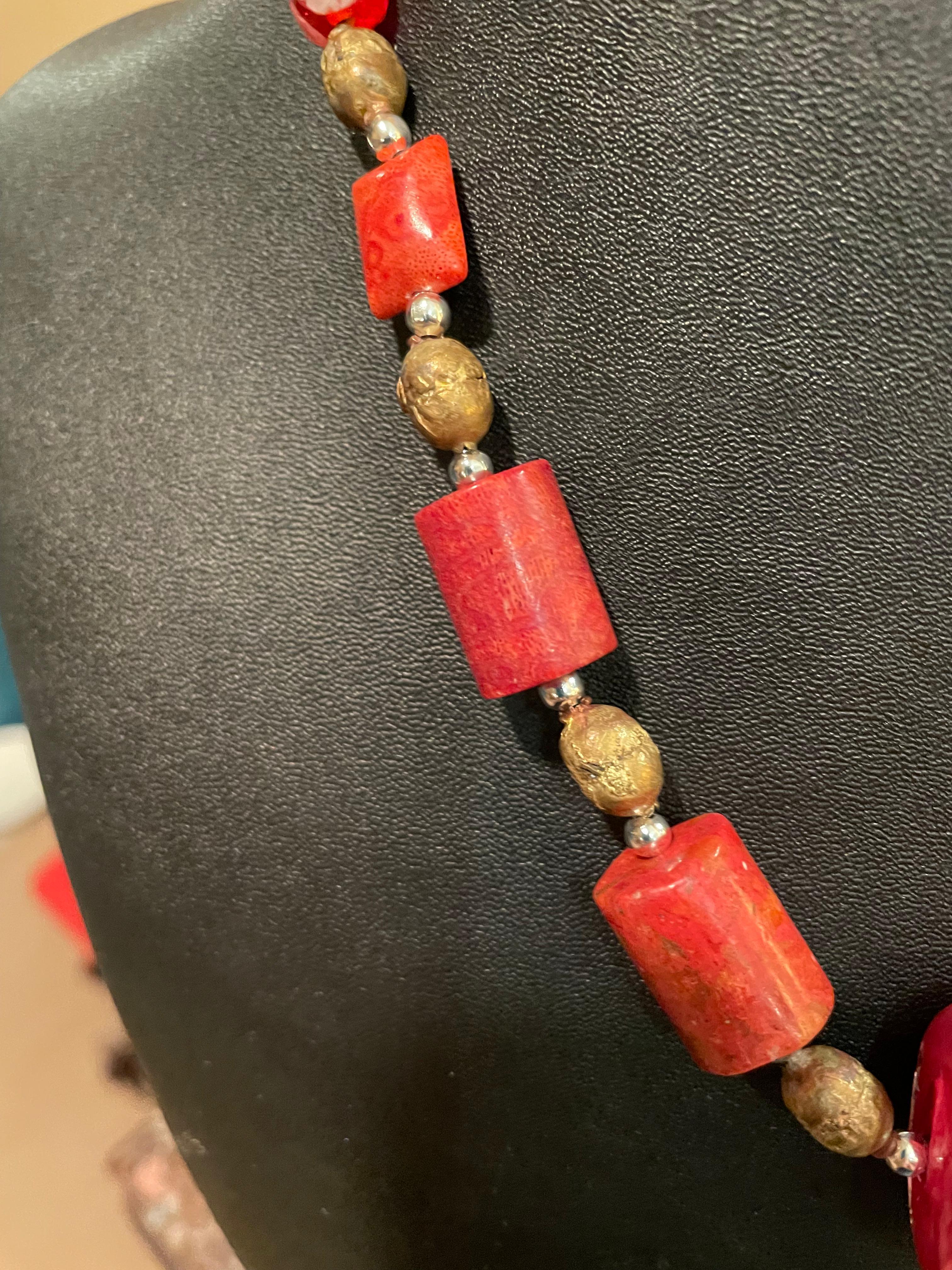 Lorraine’s Bijoux offers a handmade, one of a kind, Venetian bead and Chinese coral necklace. The center piece Venetian bead was handmade in Murano and includes both silver and gold pieces embedded in the glass. This bead is enhanced by lovely beads