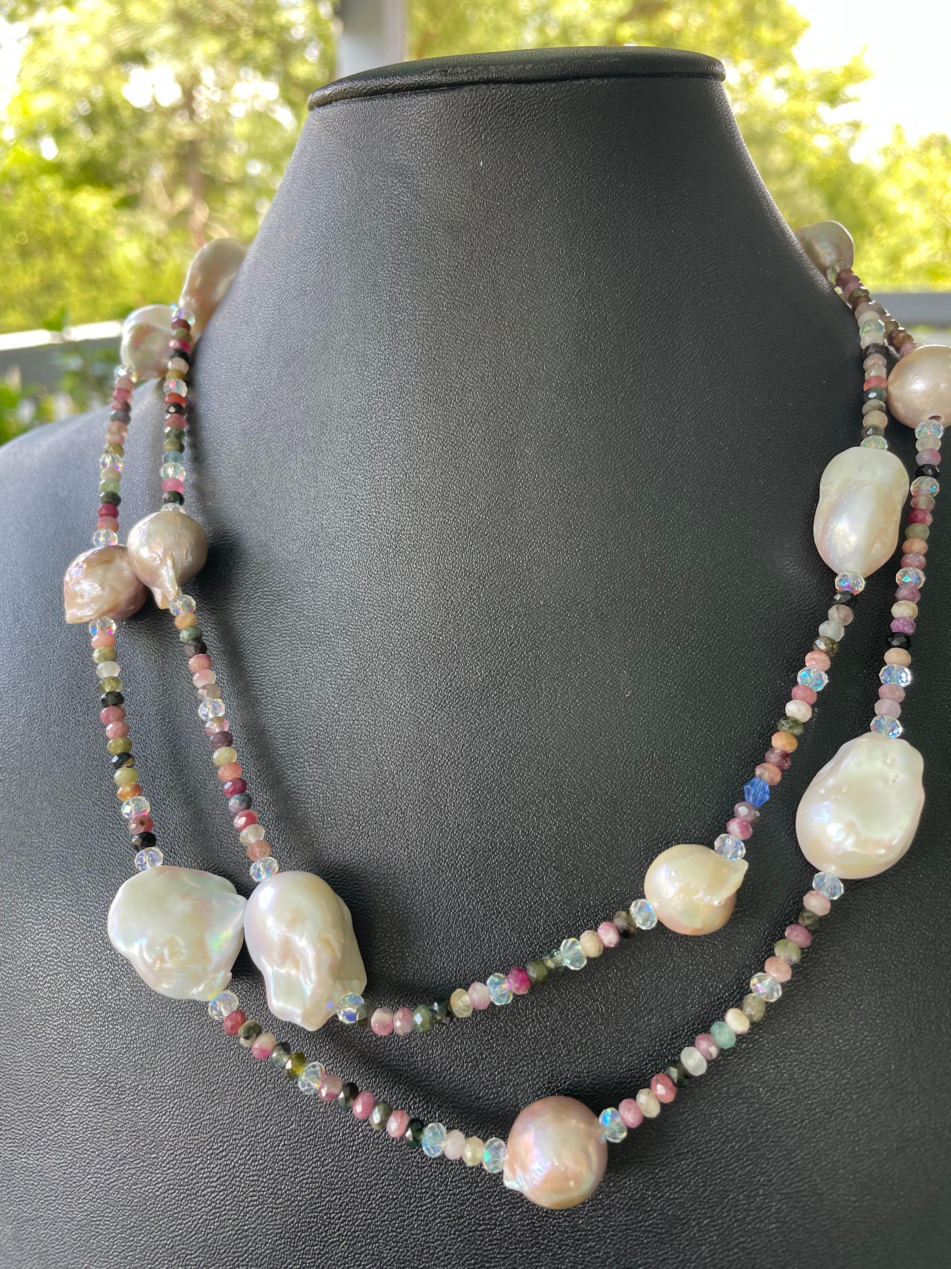 Lorrain's Bijoux bietet einen langen Strang mit weißen und mauvefarbenen chinesischen Süßwasser-Barockperlen an. Die Abstandshalter g Co bestehen aus kleinen facettierten naturfarbenen Turmalinperlen und kleinen facettierten Swarovski AB 