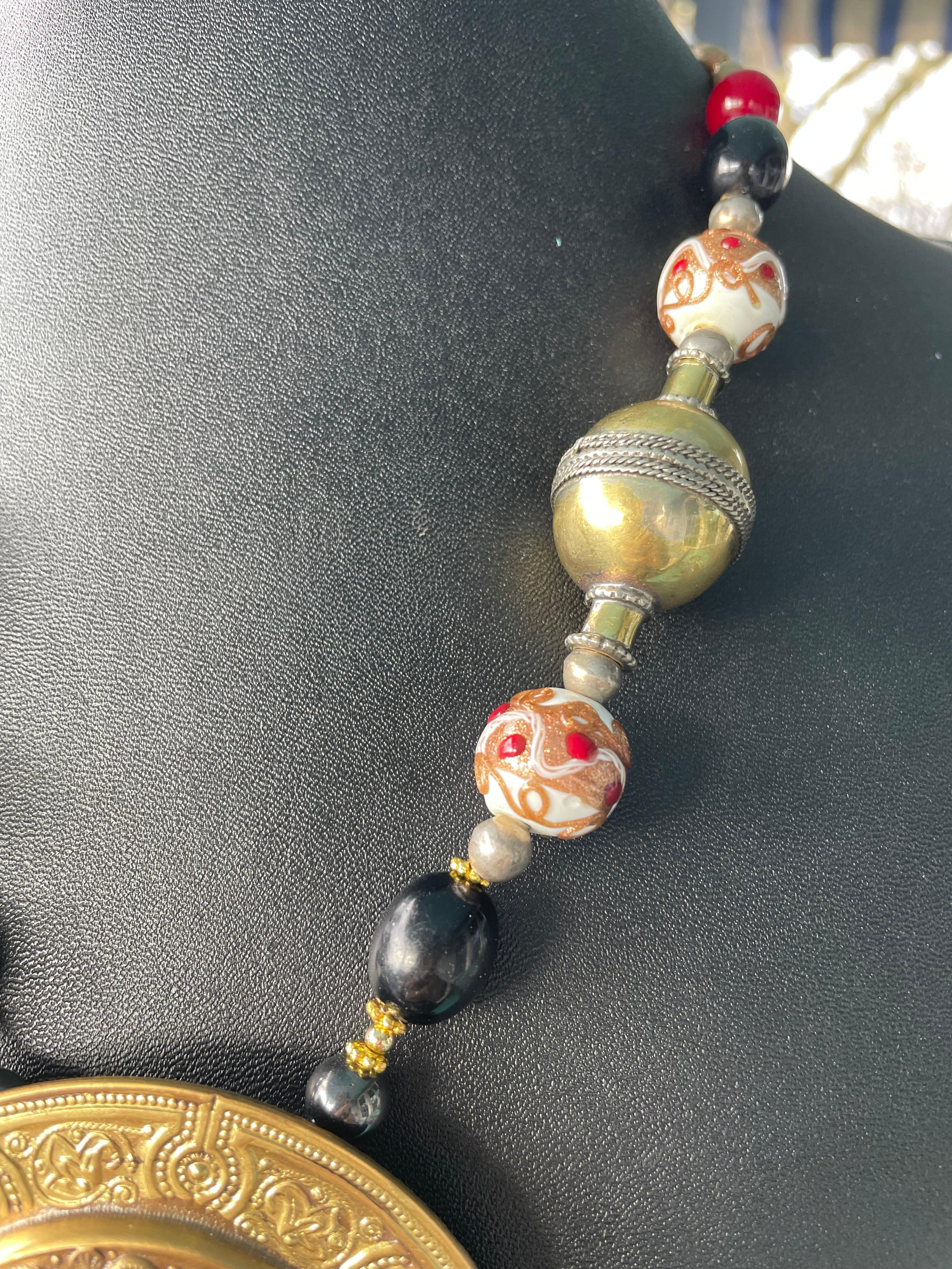 Artigiano LB offre una collana in ottone con medaglione cesellato, leone tibetano, vetro veneziano e corniola in vendita