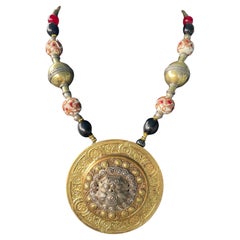 LB offre una collana in ottone con medaglione cesellato, leone tibetano, vetro veneziano e corniola