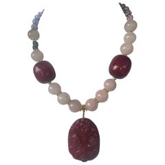 LB propose un collier en bakélite, pierre chinoise sculptée, quartz rose et verre