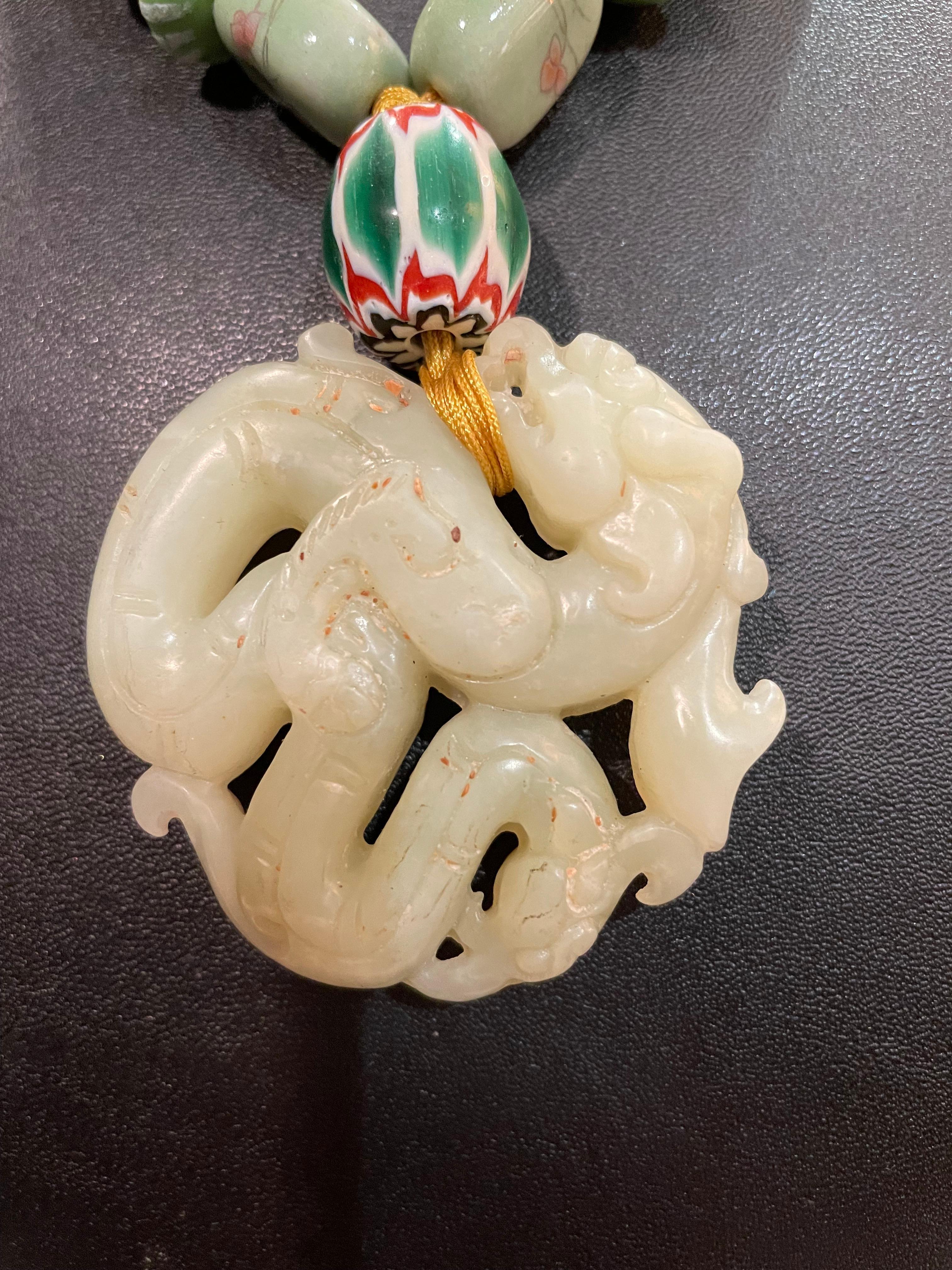 Lorraine’s Bijoux has on offer a Vintage; hand carved dragon pendant on gold cord .
Large Venetian glass chevron beads, squared off green agate beads, glass discs,
Handmade red and green disc beads add drama to this striking piece. Silver cylinder