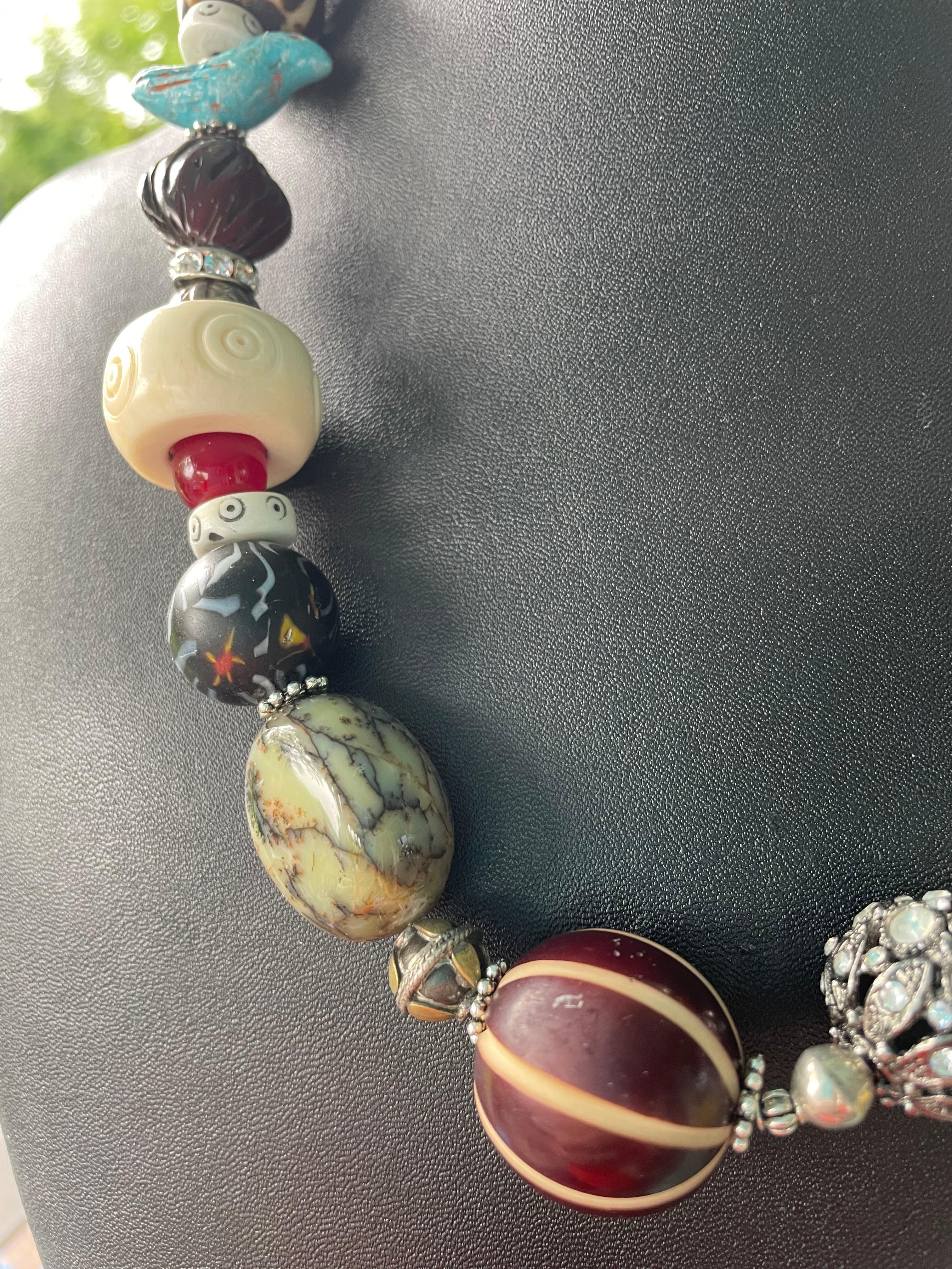 Lorraines' Bijoux aveva in offerta una collana di perline africane, osso, cristallo e legno. Questa variegata collezione di noci e noccioli di pesca, uccelli in ceramica turchese, rondelle d'osso intagliate, agate, resina vintage intagliata,