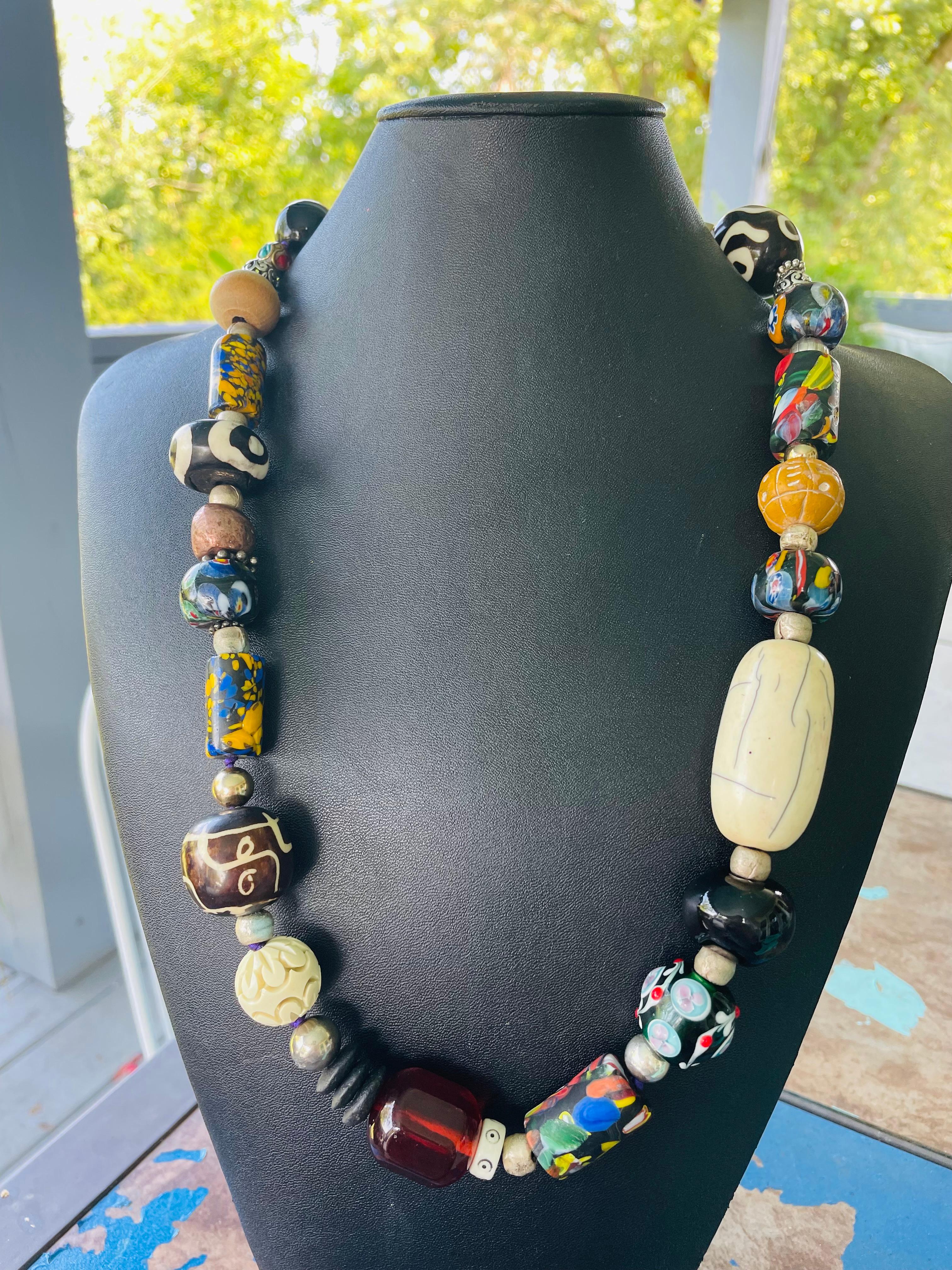 Lorraines' Bijoux propone una collana di perline in stile tribale. La combinazione di perle di vetro veneziano, ambra dorata, perle di ceramica africana e perle di osso,  Pietre, resina intagliata d'epoca, sughero e perline di legno, argento e rame,