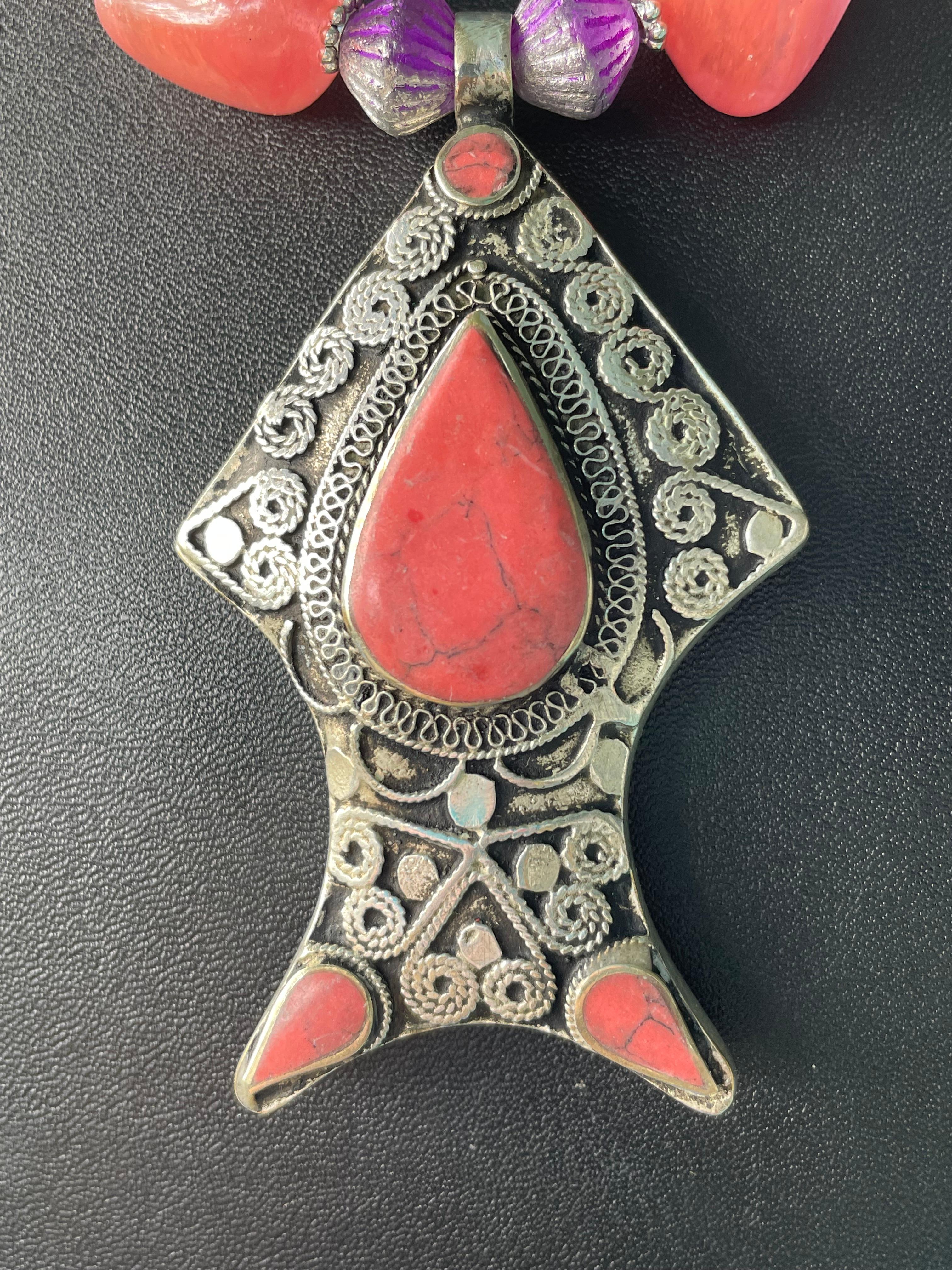 Lorraine's Bijoux tiene en oferta un Colgante tibetano grande de coral y plata en forma de pez 
Collar. Esta dramática pieza marca el tono de las grandes cuentas de cuarzo rosa de forma irregular y de las cuentas venecianas de cristal morado y las
