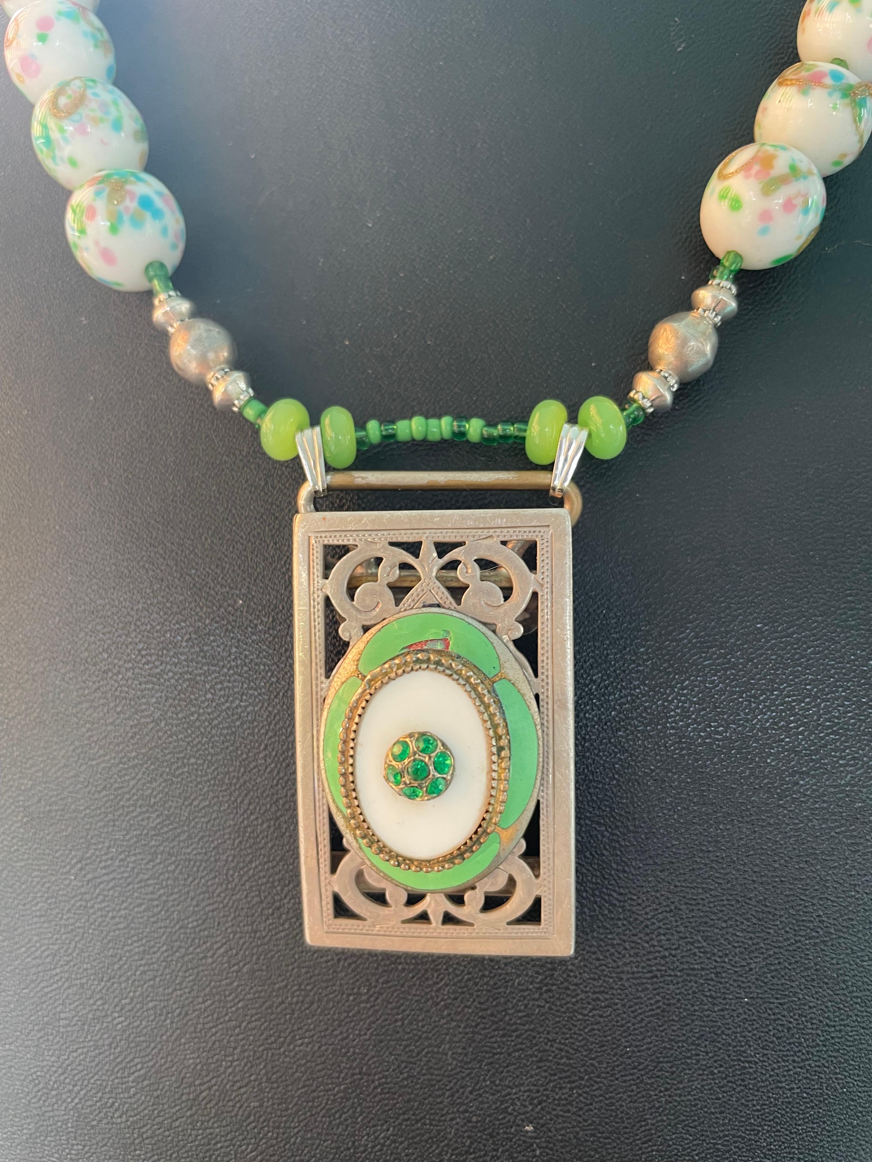 Lorraine’s Bijoux has on offer a Vintage French enamel and Sterling Silver Brooch, an Antique Sterling Silver belt buckle centerpiece Necklace. The mottled vintage Czech glass white beads and vintage green Peking glass beads serve to enhance the