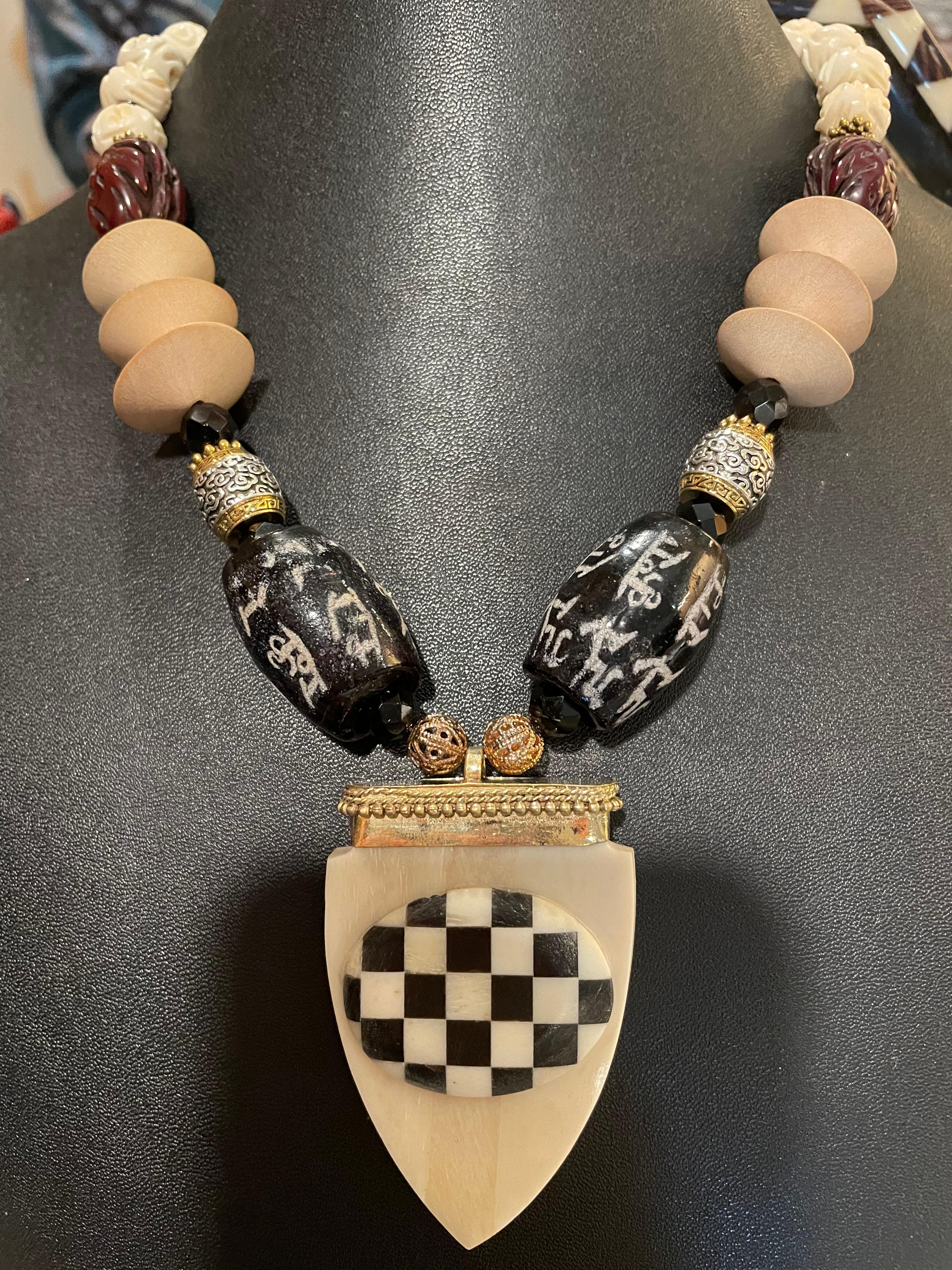 Lorraine's Bijoux bietet eine große indische Halskette mit geschnitzten und eingelegten Anhängern aus Knochen und Messing an. Große chinesische schwarze Glasperlen im Vintage-Stil, Fassperlen aus Silber und Messing, große unbearbeitete