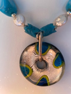 LB propone una collana con ciondolo in stile Murano, con perla in vetro turchese MOP, cristallo e acciaio inossidabile