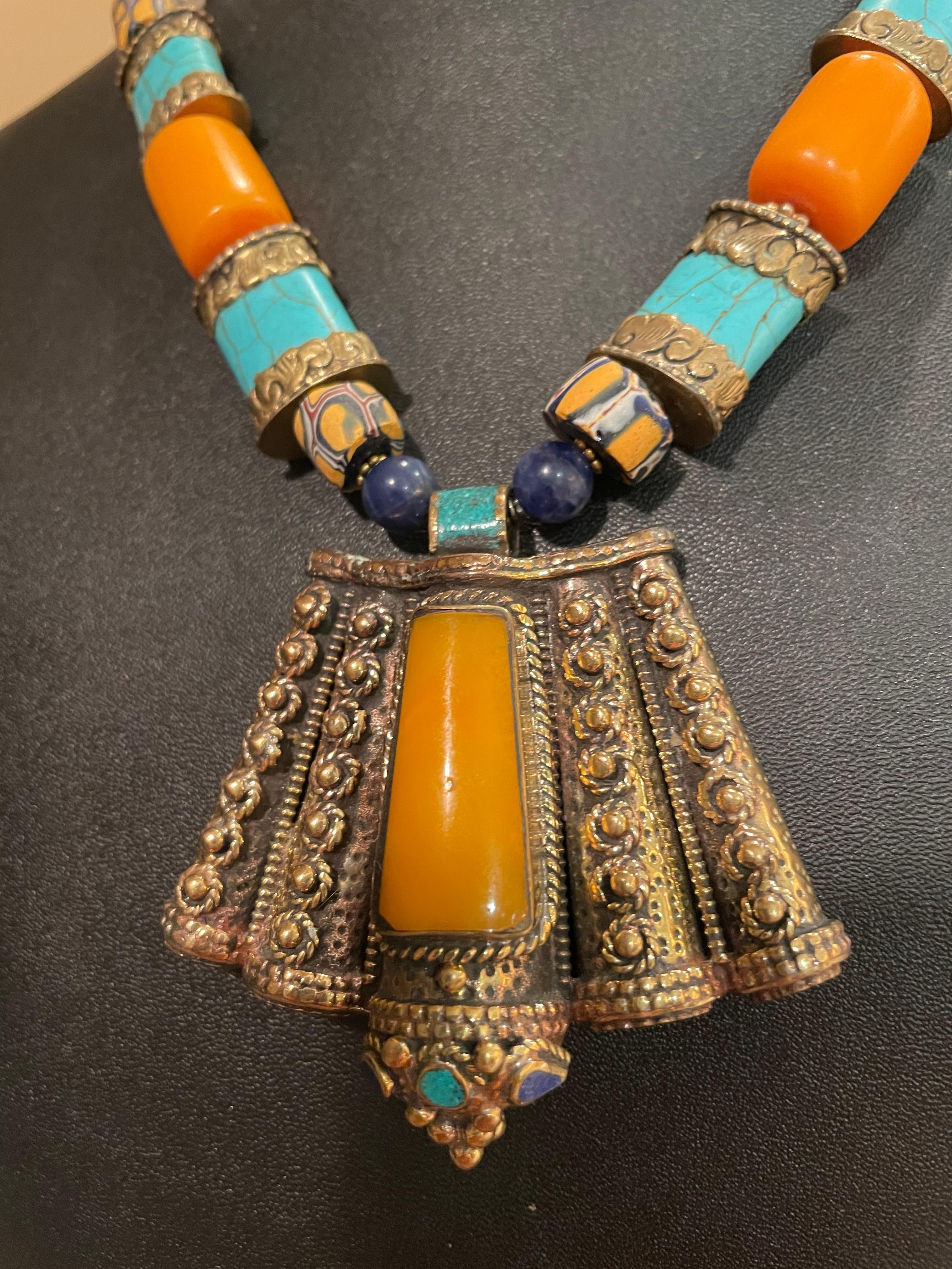Lorraine’s Bijoux offers a Stunning Tibetan inlaid Brass pendant necklace. This very unusual pendant has inlays of of Turquoise and Lapis Lazuli along with ‘Amber’ resin and features hand wrought brass metalwork.
Handmade brass and turquoise barrel