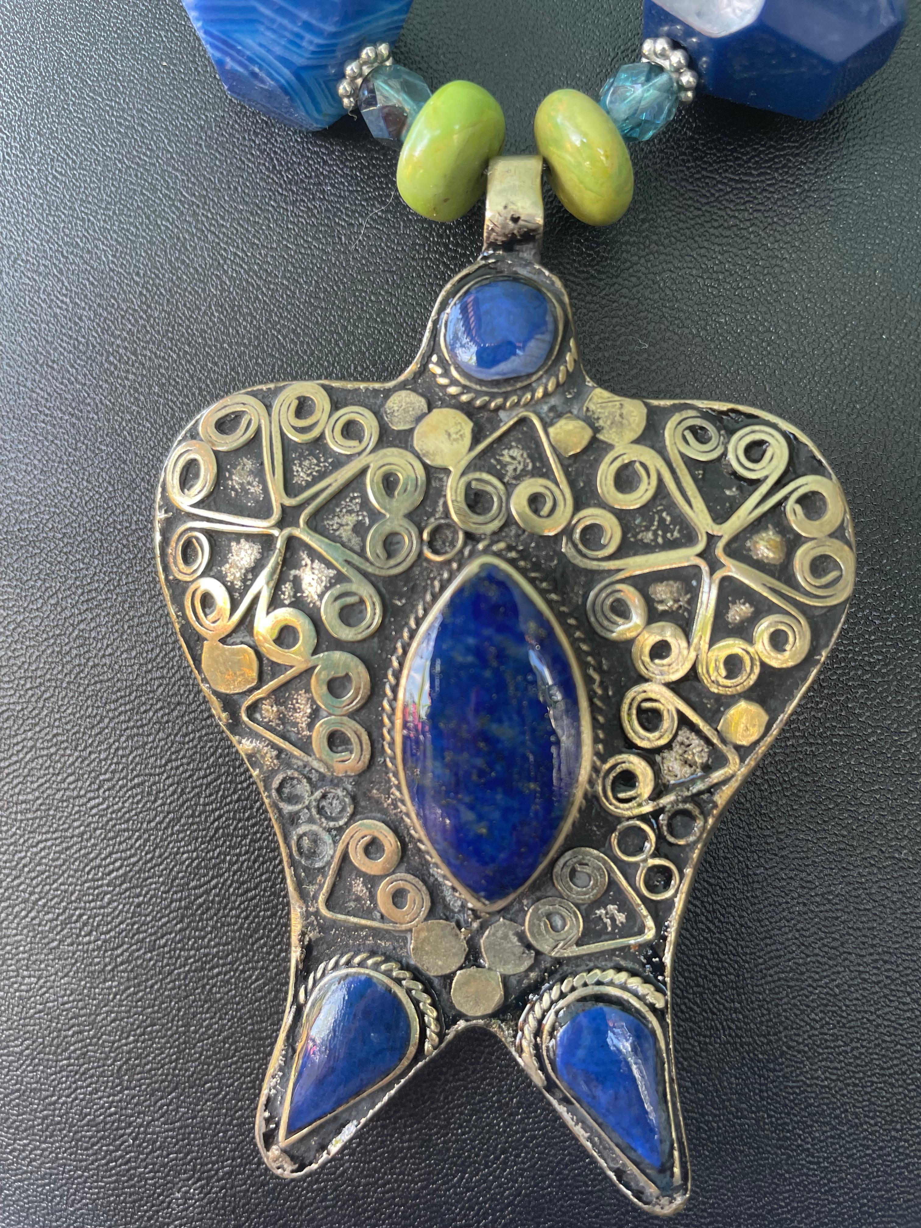 Lorraine’s Bijoux has on offer a vintage Tibetan Silver and Lapis Lazuli pendant necklace. The shape of the pendant is almost the shape of a large exotic Butterfly inlaid with Cabachon Lapis Lazuli inlays. The strand of beads consists of Faceted