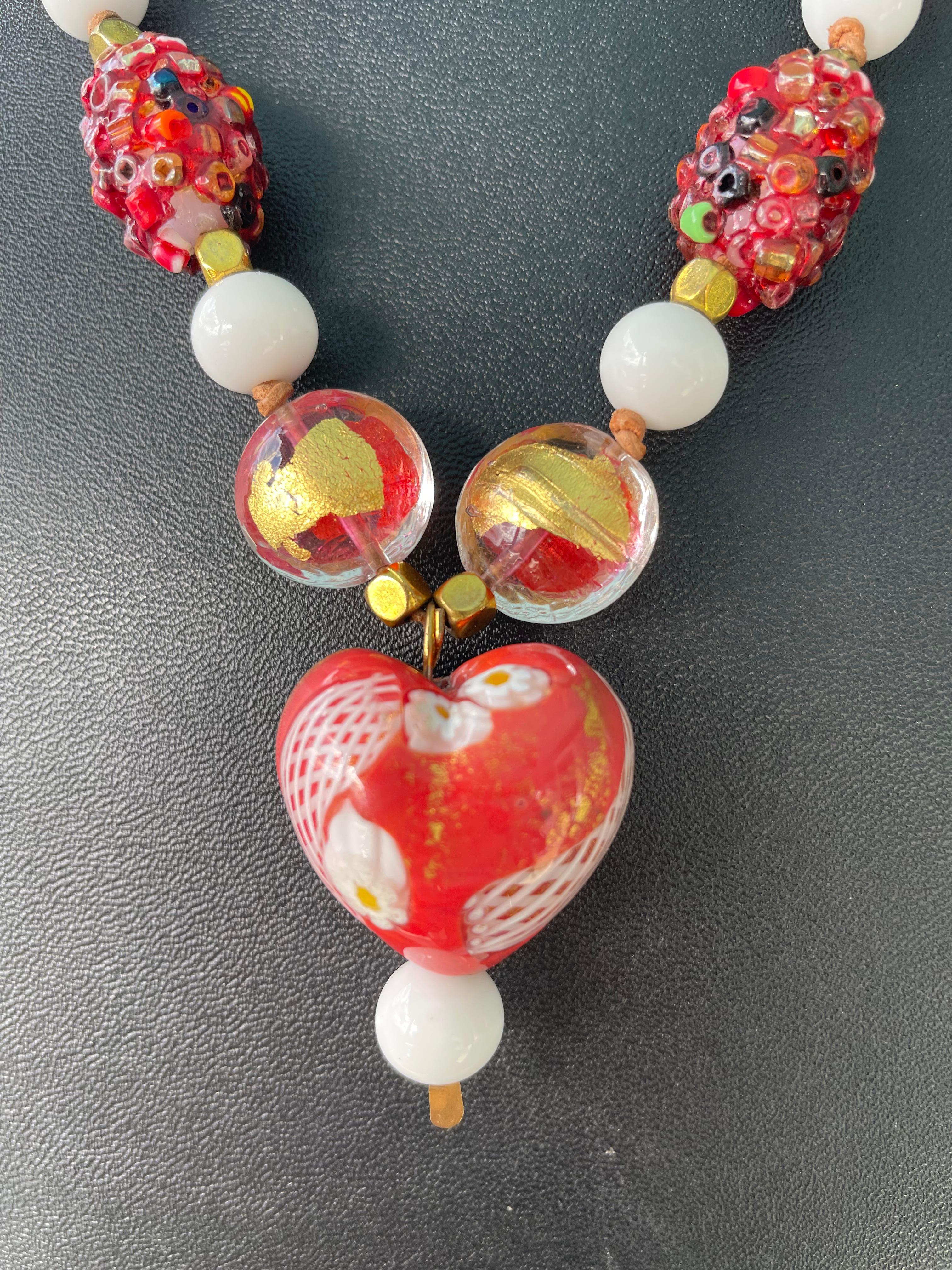 Lorrain's Bijoux propose un collier pendentif vintage en verre soufflé vénitien.
Les perles rouges incrustées sont de Rome et les perles bicolores rouges et or sont également vénitiennes. Des perles américaines vintage en verre blanc, des ronds de