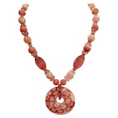 LB propose un collier pendentif en verre vénitien RQ Rock Crystal, en verre rose vintage et acier inoxydable