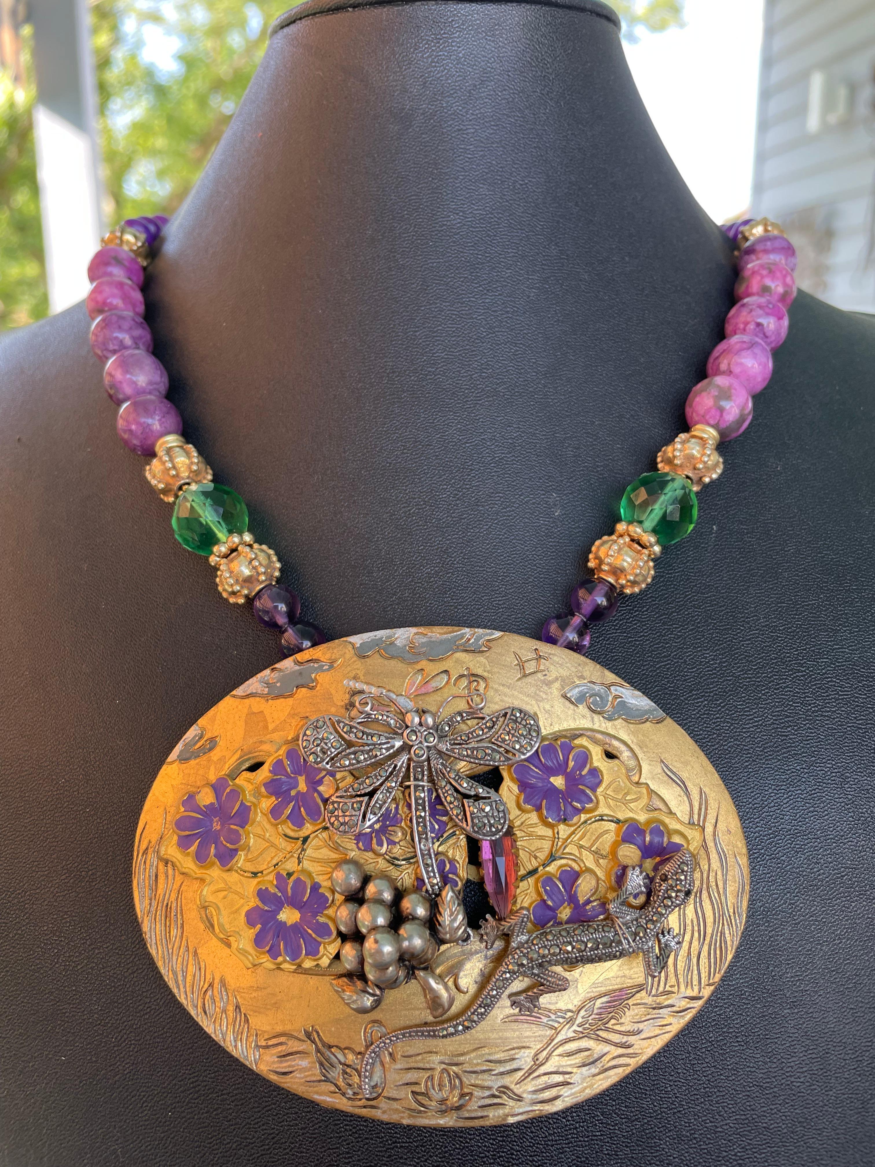 Lorraine’s Bijoux offers a one of a kind, handmade, Vintage Brass, French Art Nouveau belt buckle centerpiece necklace. 
This buckle is layered with vintage Sterling Silver and Marcasite animal brooches and another brass and purple enamel antique