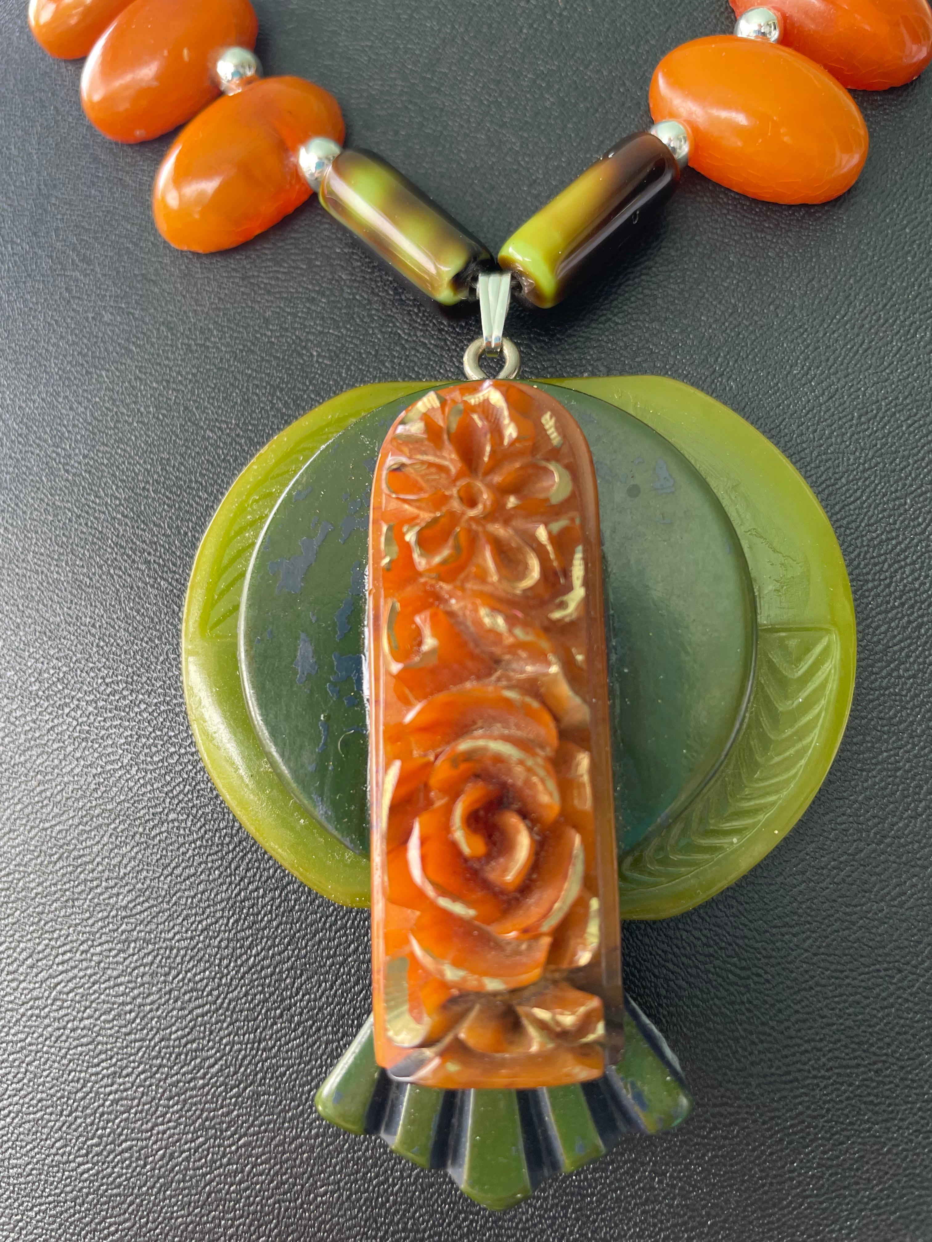 Lorraines' Bijoux propone una collana in ambra Butterscotch e bachelite vintage. Due fibbie vintage in bachelite verde e un ciondolo in bachelite color oro intagliato sono stati uniti per creare un centrotavola mozzafiato. Il tutto è arricchito da