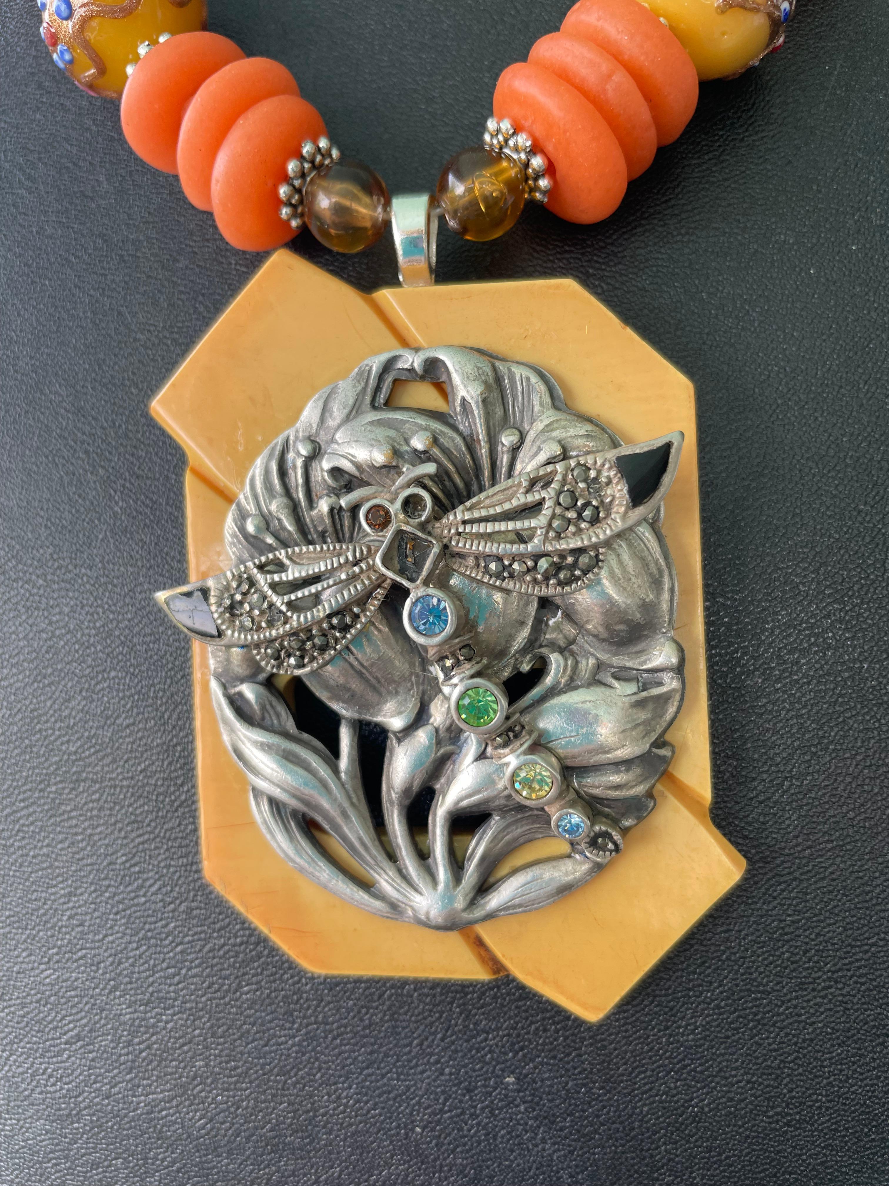 Lorrain's Bijoux propose une boucle vintage en bakélite et deux broches vintage en argent, marcassite et onyx incrusté.
Des perles de mariage en verre vénitien jaune et des disques de corail en verre africain accentuent et mettent en valeur le