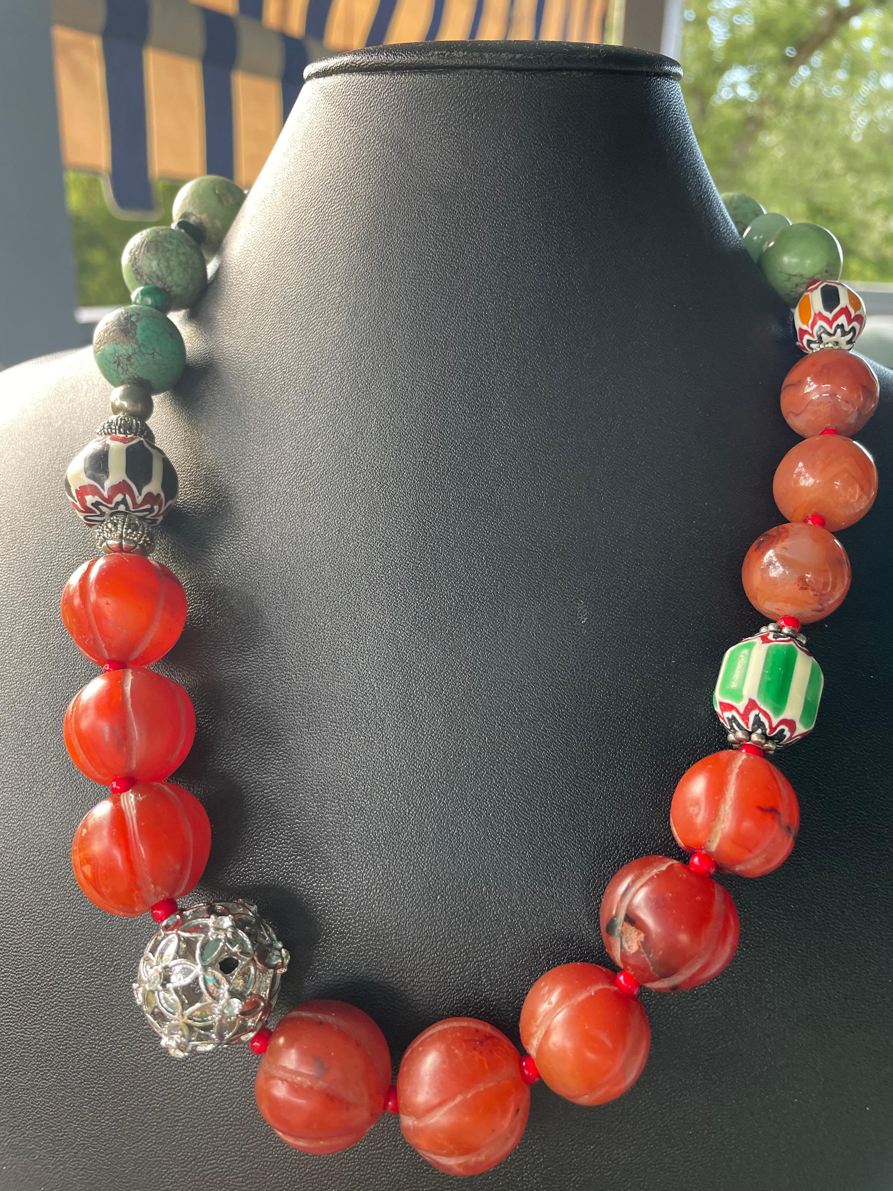 Lorraine’s Bijoux has on offer a necklace of Vintage, handcarved, gourd shaped Tibetan Carnelian beads, Green Turquoise round beads, Vintage Venetian glass trade beads, large filigreed silver statement bead, with malachite spacers, this piece is