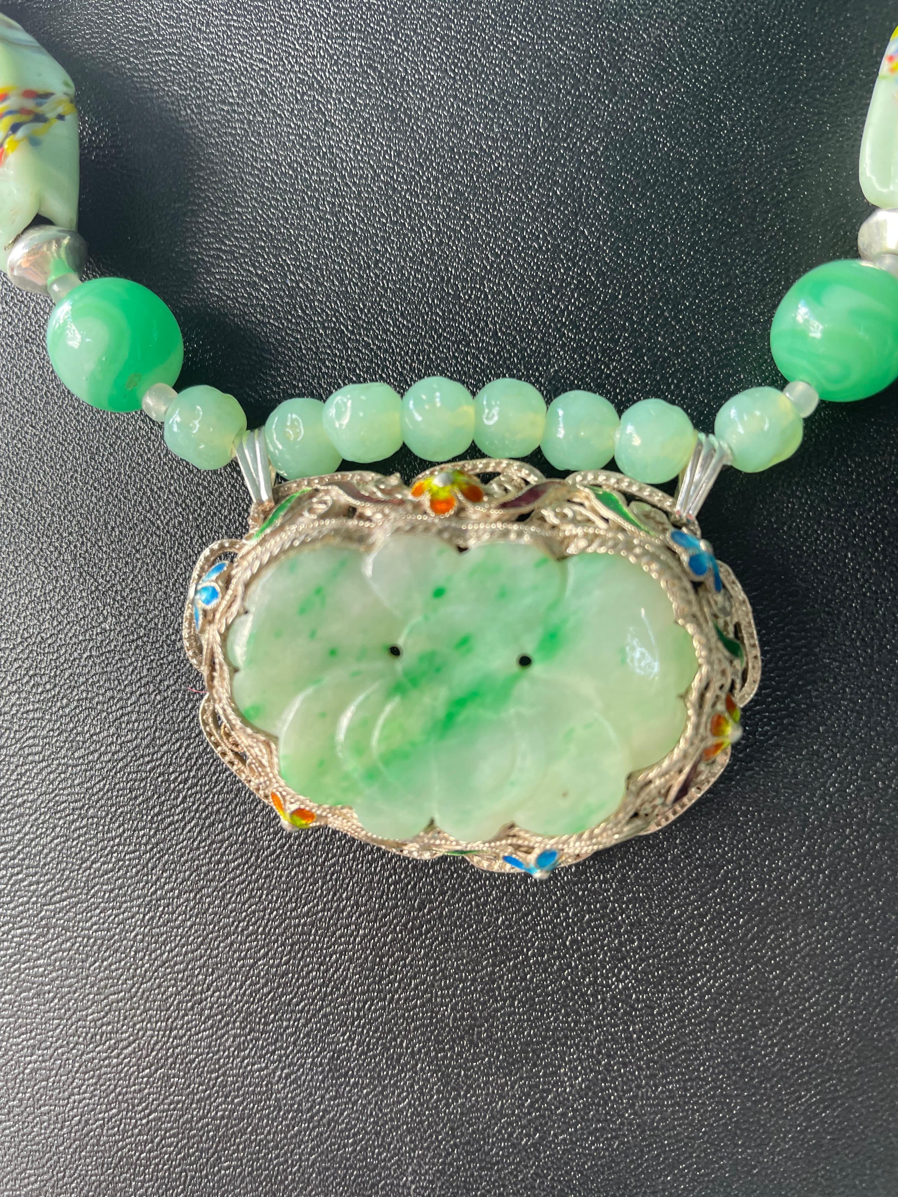 Lorraine's Bijoux bietet eine Brosche aus geschnitzter grüner Jade im Vintage-Stil mit filigraner Sterling-Silberarbeit und handemailliertem Blumendekor an. Der Strang aus geschnitzten chinesischen Perlen, gesprenkelten Pekinger Glasperlen, großen