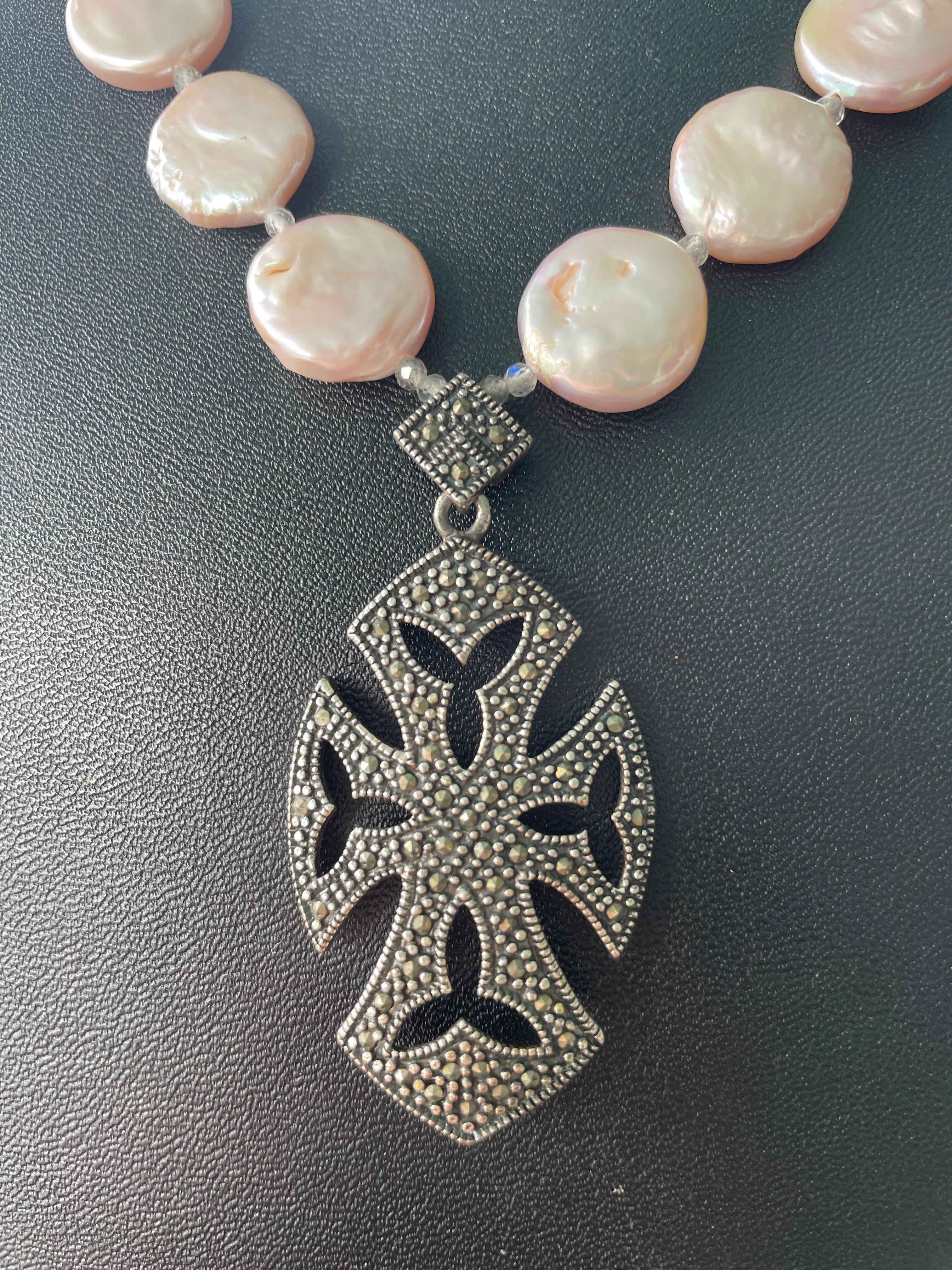 Lorraines' Bijoux propone un ciondolo a croce di Malta d'epoca in Marcasite e Argento Sterling. Le perle rosa d'acqua dolce Coin Pearls e le perle Peacock aggiungono delicatezza a questo pezzo. Rondelle con cristalli e perline rotonde di agata