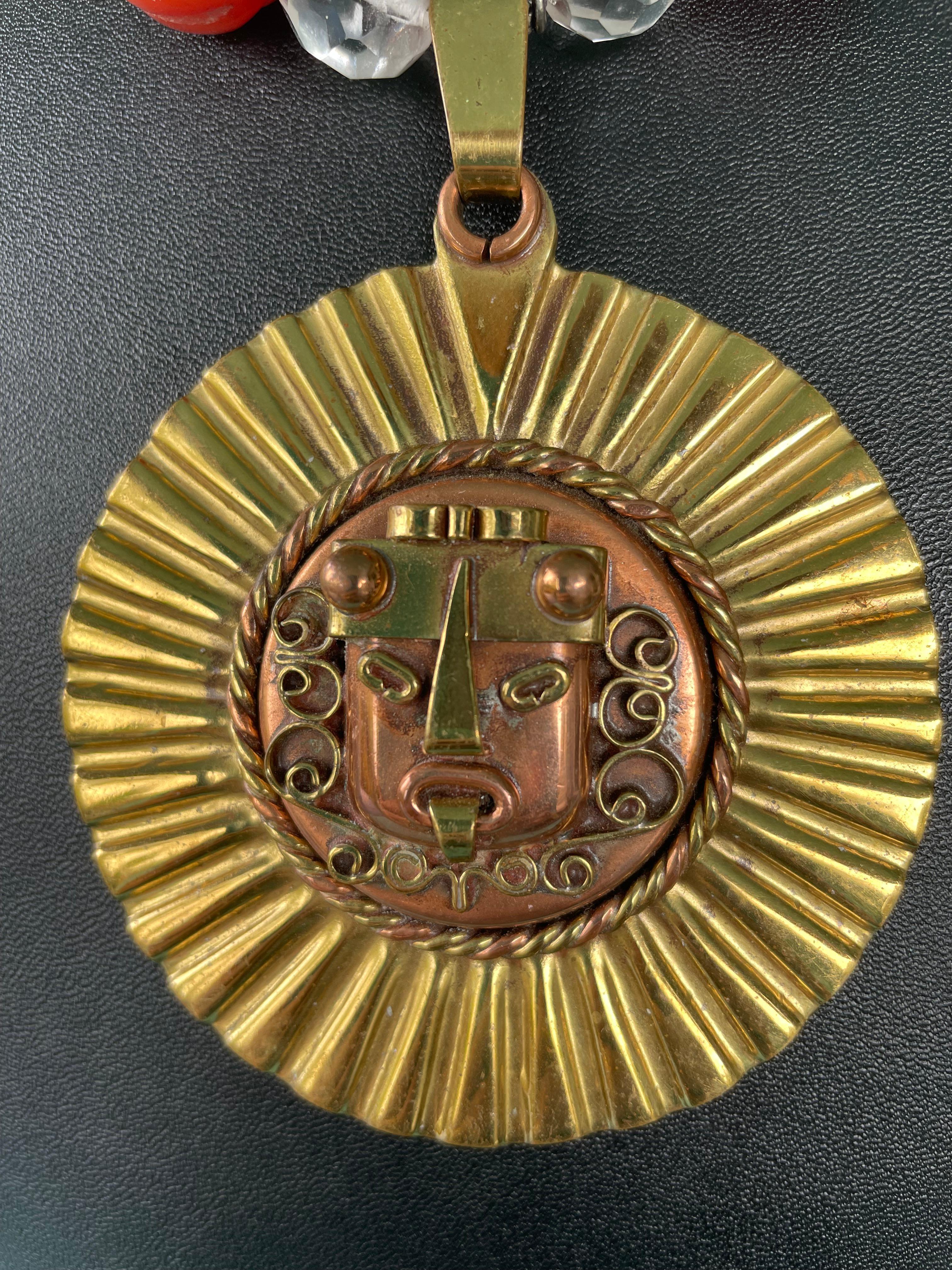 Lorraine’s Bijoux has on offer a Large, Vintage, Mexican Copper and Brass Aztec style Mask pendant. This necklace is Dramatic and is enhanced with large melon shaped, handcarved Carnelian beads, Vintage Tibetan brass inlaid beads, Vintage Venetian