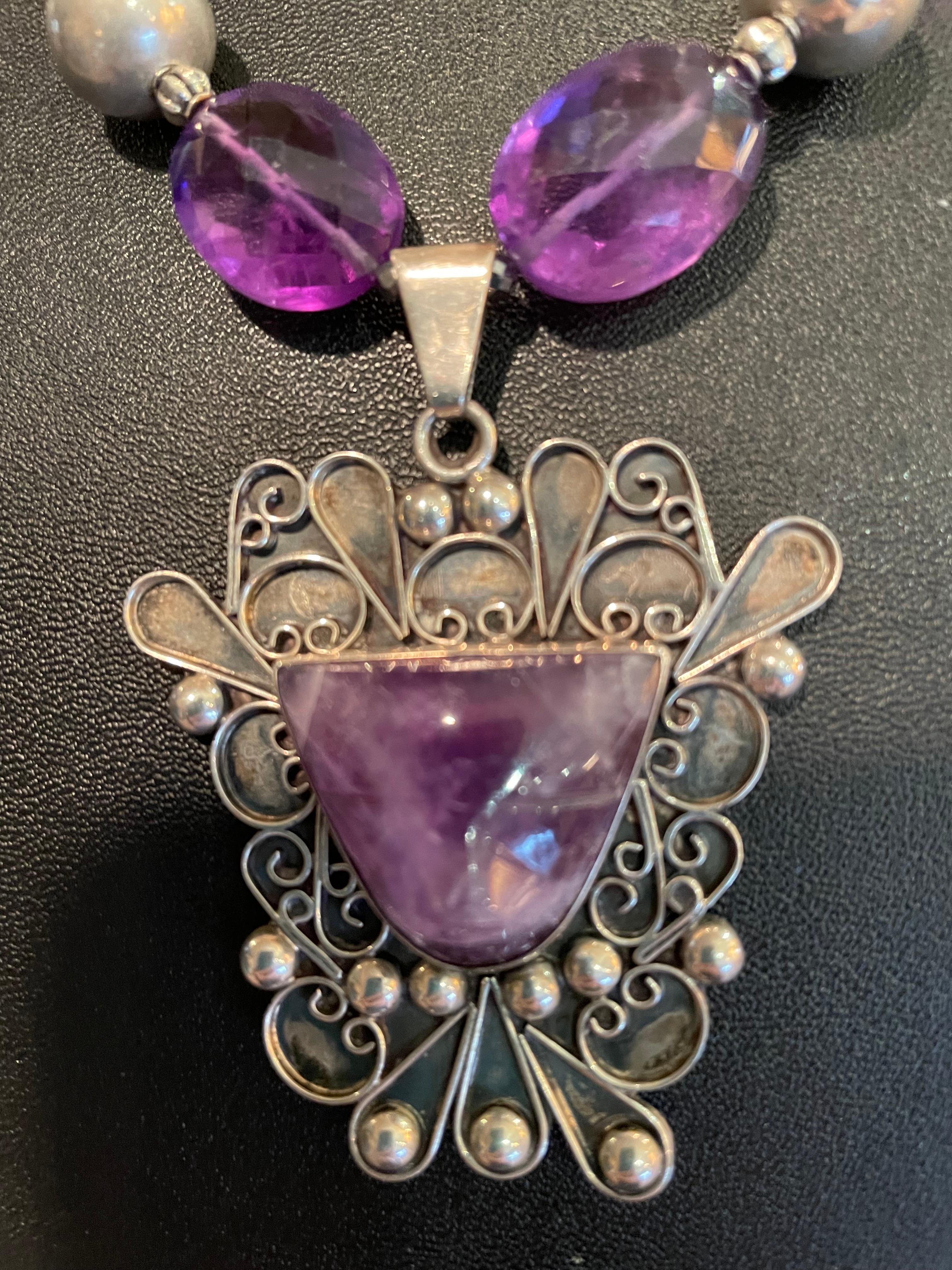 Lorraine’s Bijoux offers a Vintage Mexican Sterling Silver and Amethyst Aztec style Pendant , one of a kind, handmade, Stunning necklace. The Amethyst stone is faceted and pyramidal in shape and is set in intricate Sterling Silver wirework. A yummy