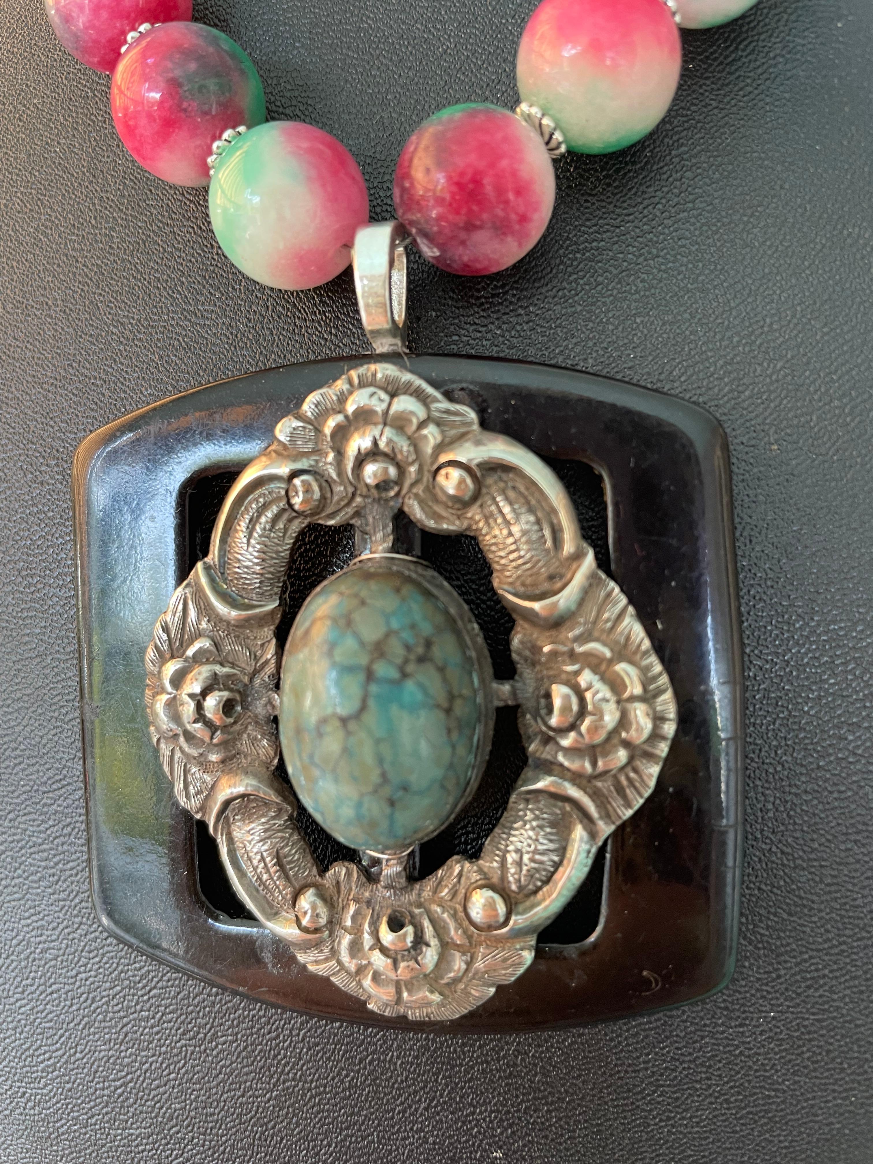 Lorraine’s Bijoux has on offer a Vintage Sterling Silver Green Turquoise and Black Bakelite buckle Pendant Necklace. The large Peking Glass pink and green beads, black onyx rounds and small bone tubes enhance this wonderful centerpiece. This piece