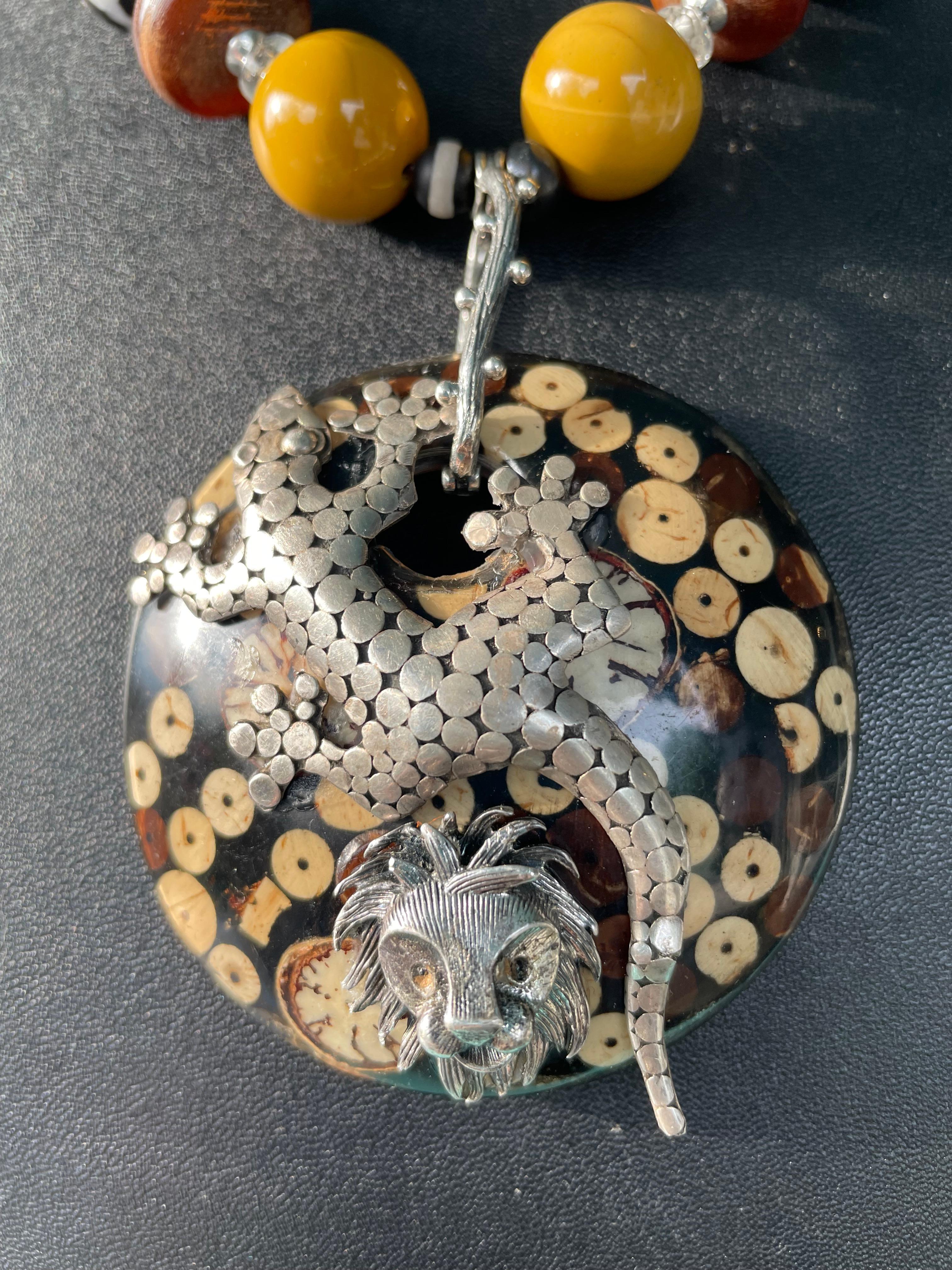 Lorraines' Bijoux propone un disco africano in legno vintage con spille d'argento vintage applicate. Un'insolita cauzione fatta a mano in argento Sterling trattiene il disco su un filo di perline Agare, dischi di legno, perline africane bianche e
