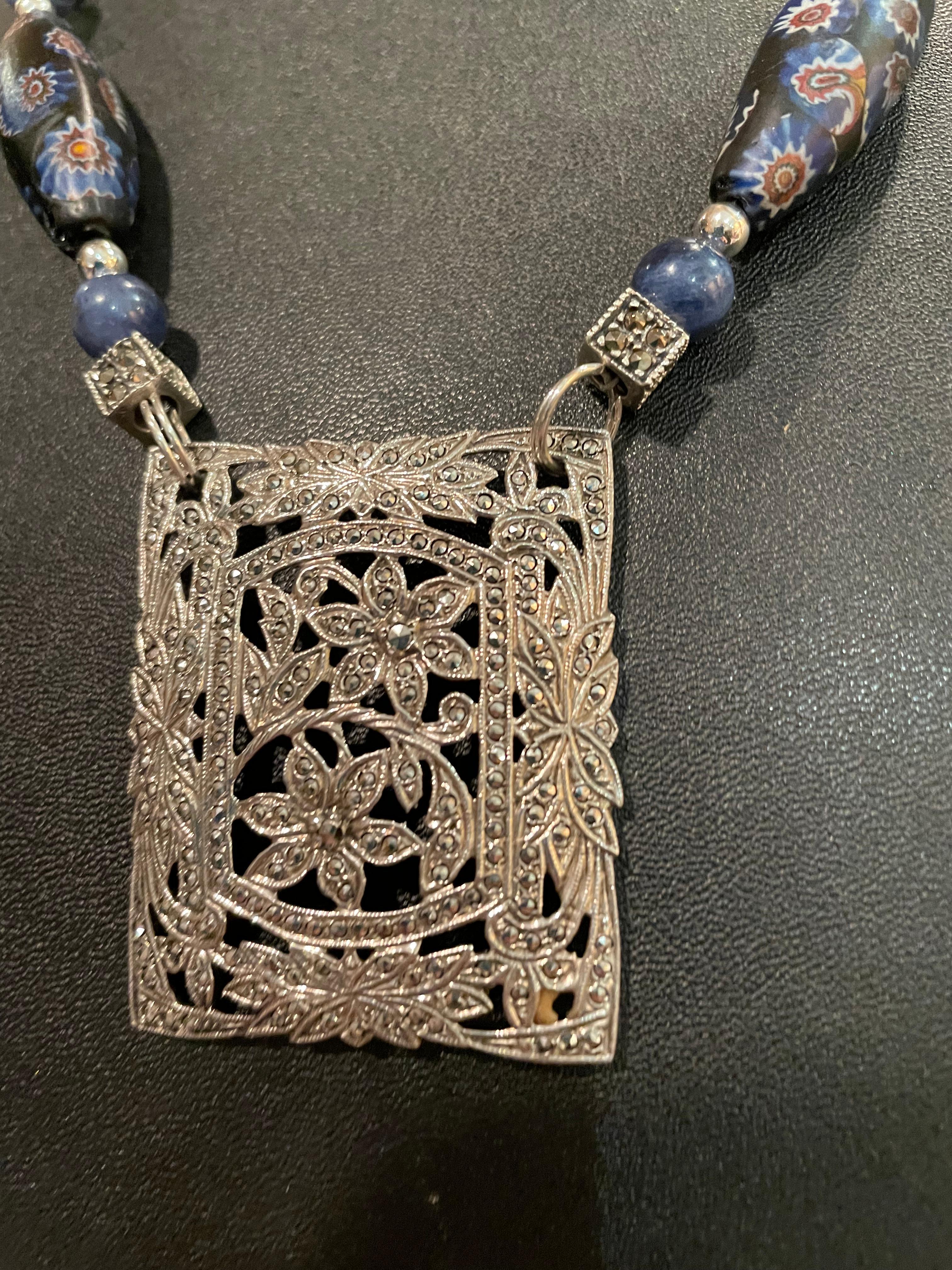 Lorraine’s Bijoux offers a Stunning Vintage Sterling Silver and Marcasite, filigree pendant that is large and impressive. The size and sparkle make it outstanding and the lapis, vintage Venetian glass, and Rock Crystal make this necklace a real