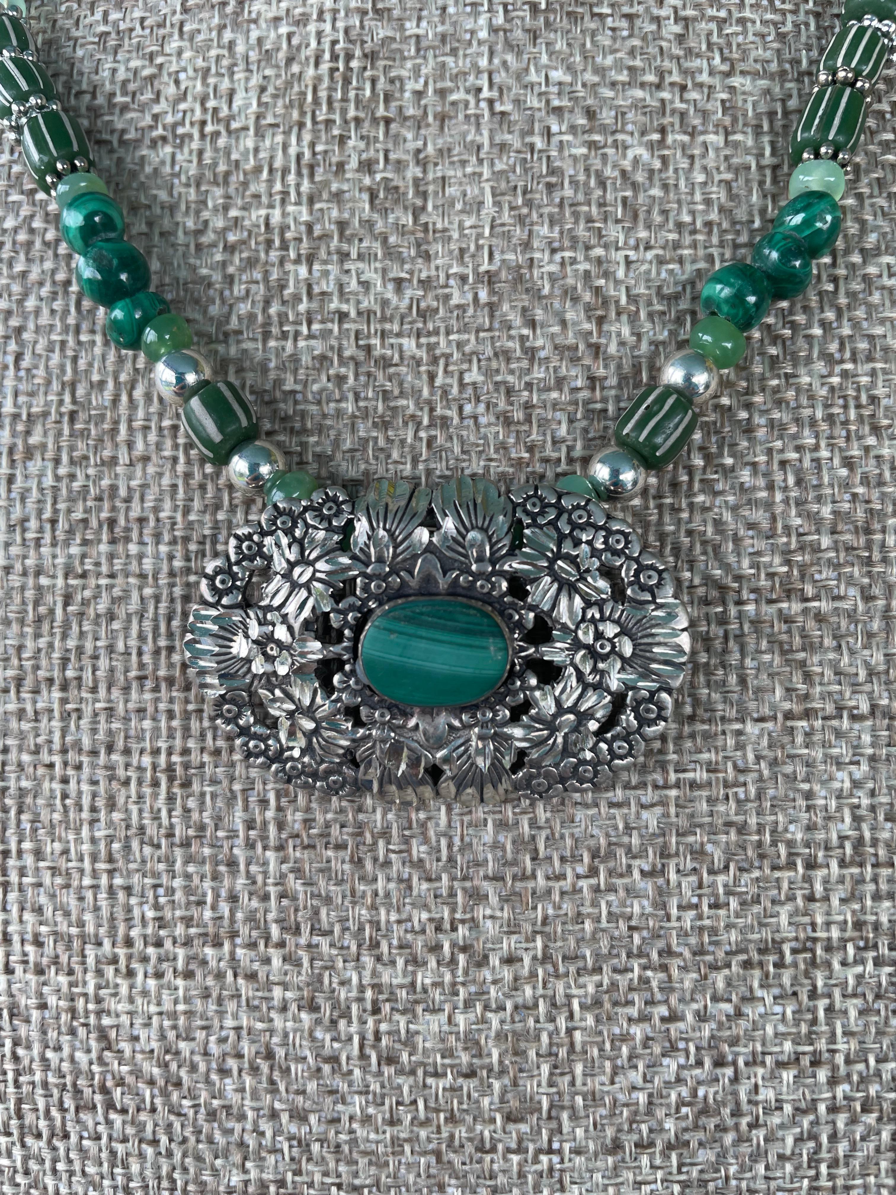 Lorraine's Bijoux ofrece un colgante vintage de plata de ley, malaquita y tallado. Una sarta de cuentas de malaquita, cristales azules vintage, cuentas de comercio venecianas vintage, plata de ley y cuentas verdes de cristal 
