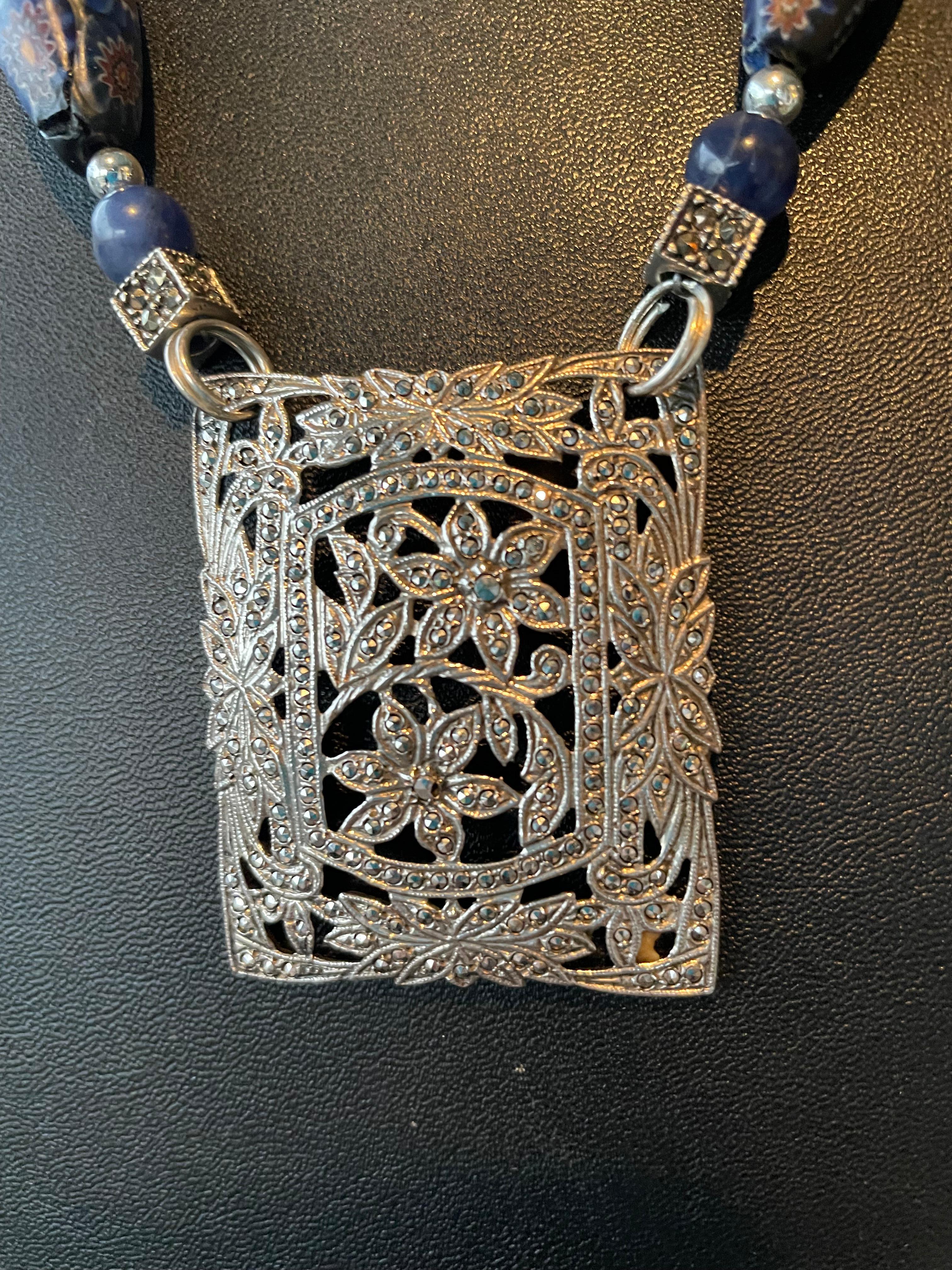 Lorraine's Bijoux tiene en oferta un Collar Colgante Broche Art Decó Vintage Francés de Plata de Ley y Marcasita. Una ristra de cuentas vintage venecianas Mille Fiore azules, cuentas de lapislázuli, rondeles de cristal de roca y cuentas cuadradas de