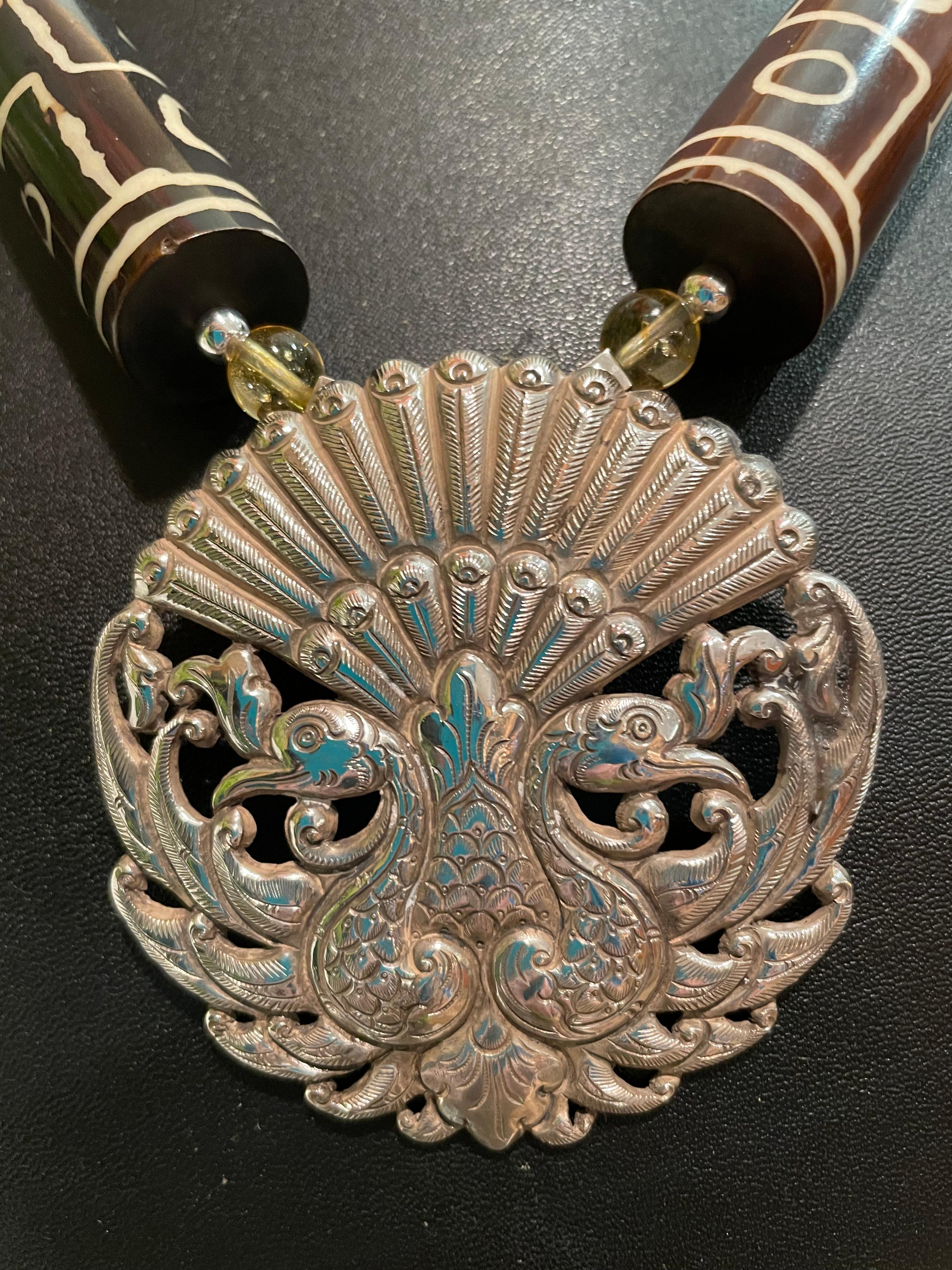 Lorraine’s Bijoux has on offer a Pendant Necklace of A Very Large Sterling Silver, Repousse, Peacock Pattern, Vintage belt Buckle Necklace. Large handmade ceramic African mud beads and hand painted pottery beads , large Tibetan Amber beads,
And