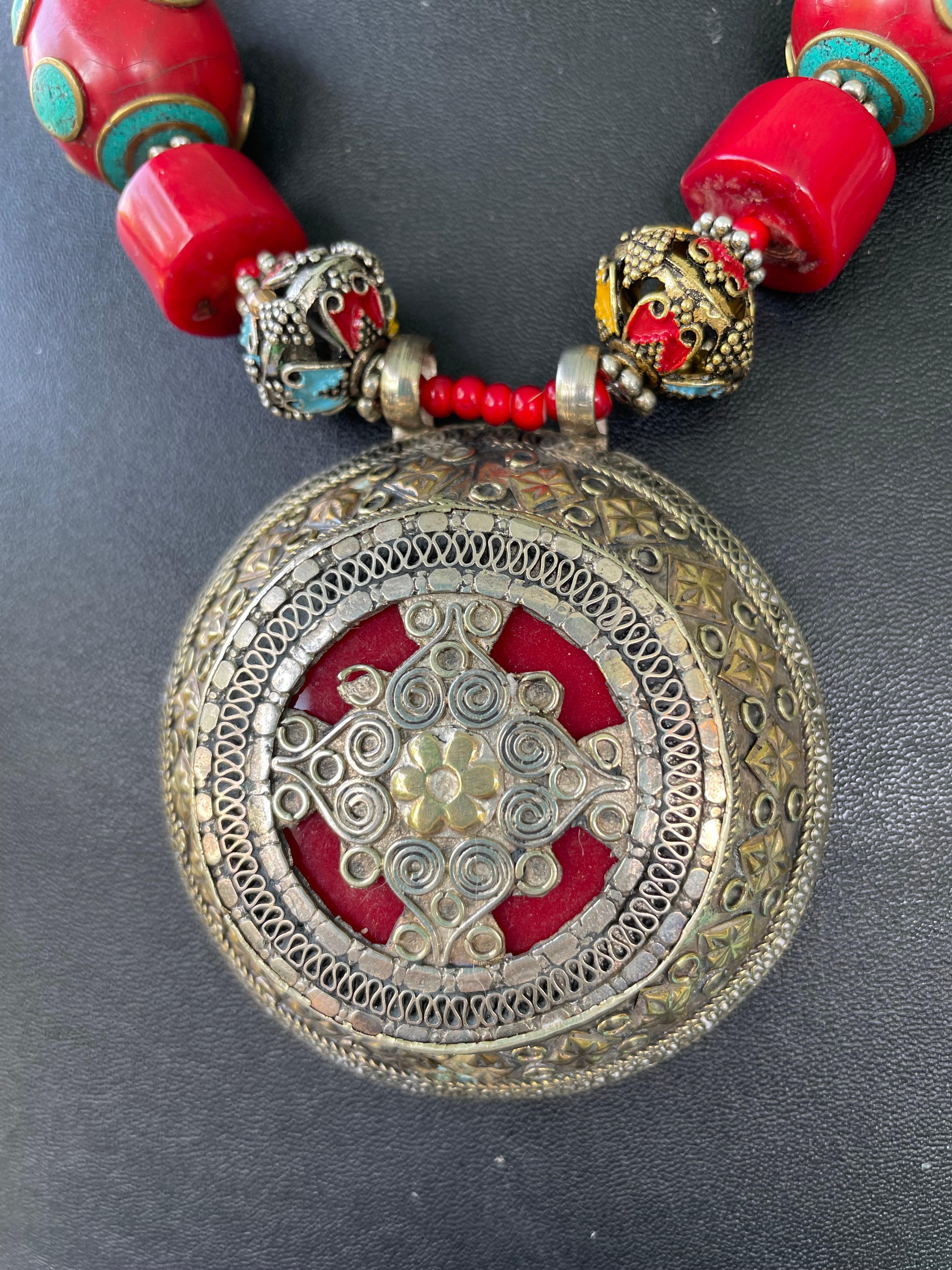Lorraine’s Bijoux has on offer a Large Vintage, Silver and enamel, Tibetan pendant necklace. Gold and Silver metalwork adorn the sides of this piece with Red Enamel work in the center. This centerpiece is large and Dramatic and hangs from a string