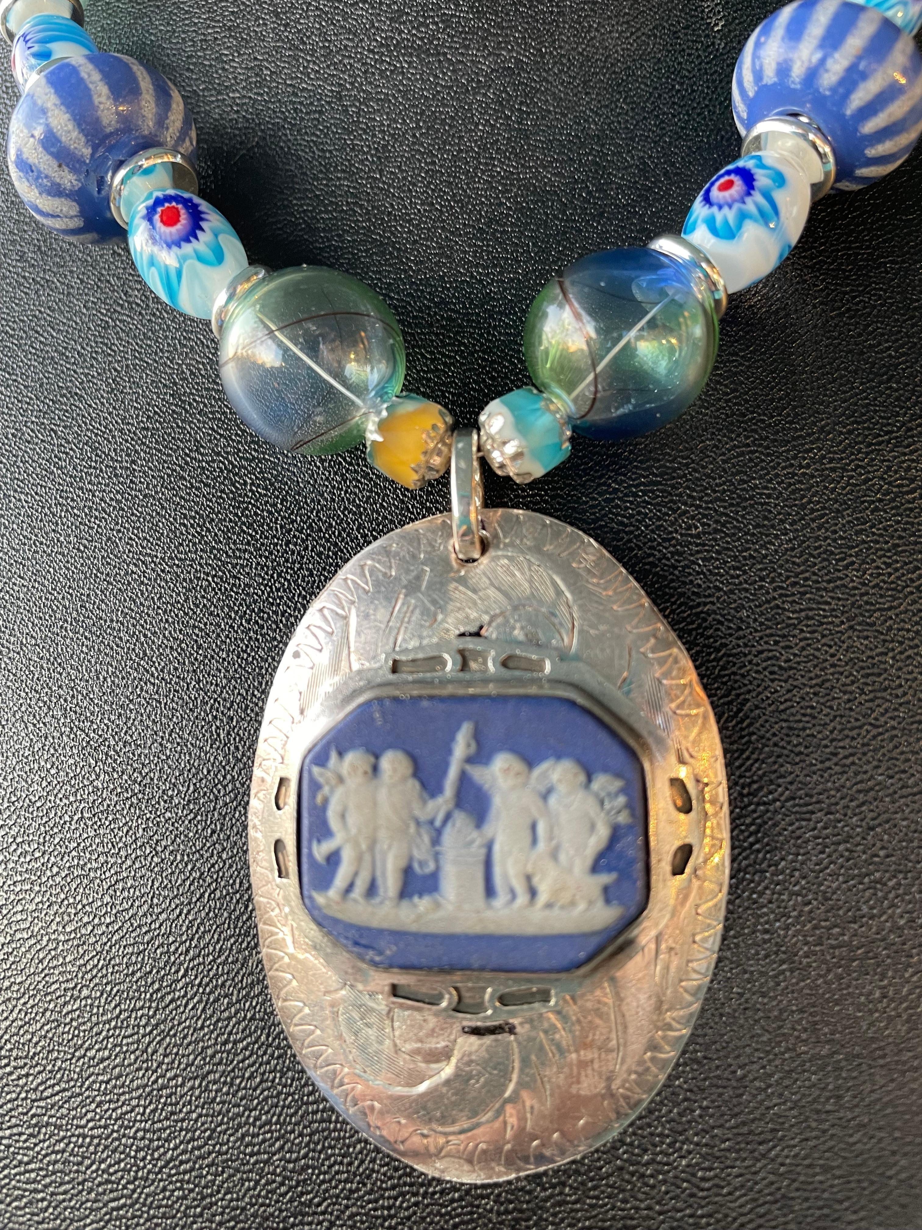 Lorraine’s Bijoux has on offer a Pendant necklace of Vintage Wedgewood Jasperware Cobalt Blue and white Classical figures Brooch on a Sterling Silver Vintage floral brooch. The Vintage blue and white Venetian glass beads and blown transparent