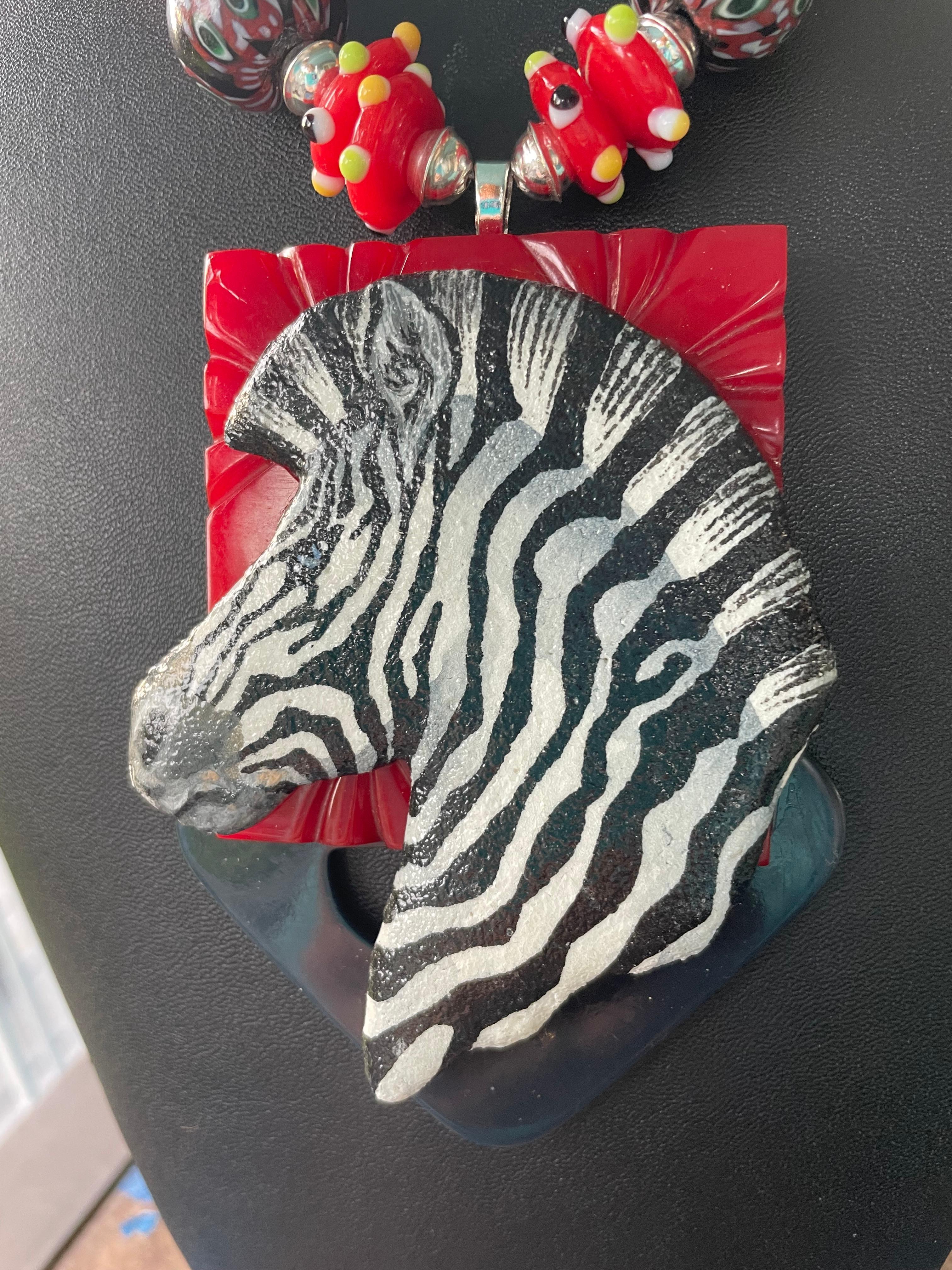 Lorraine’s Bijoux has on offer a Large Handmade and Handpainted Ceramic Zebra 
Centerpiece with two vintage Bakelite Buckles. The red one is carved. Multiple and multicolored beads of Bakelite, Coral , Jet, handmade glass rondelles, and Venetian