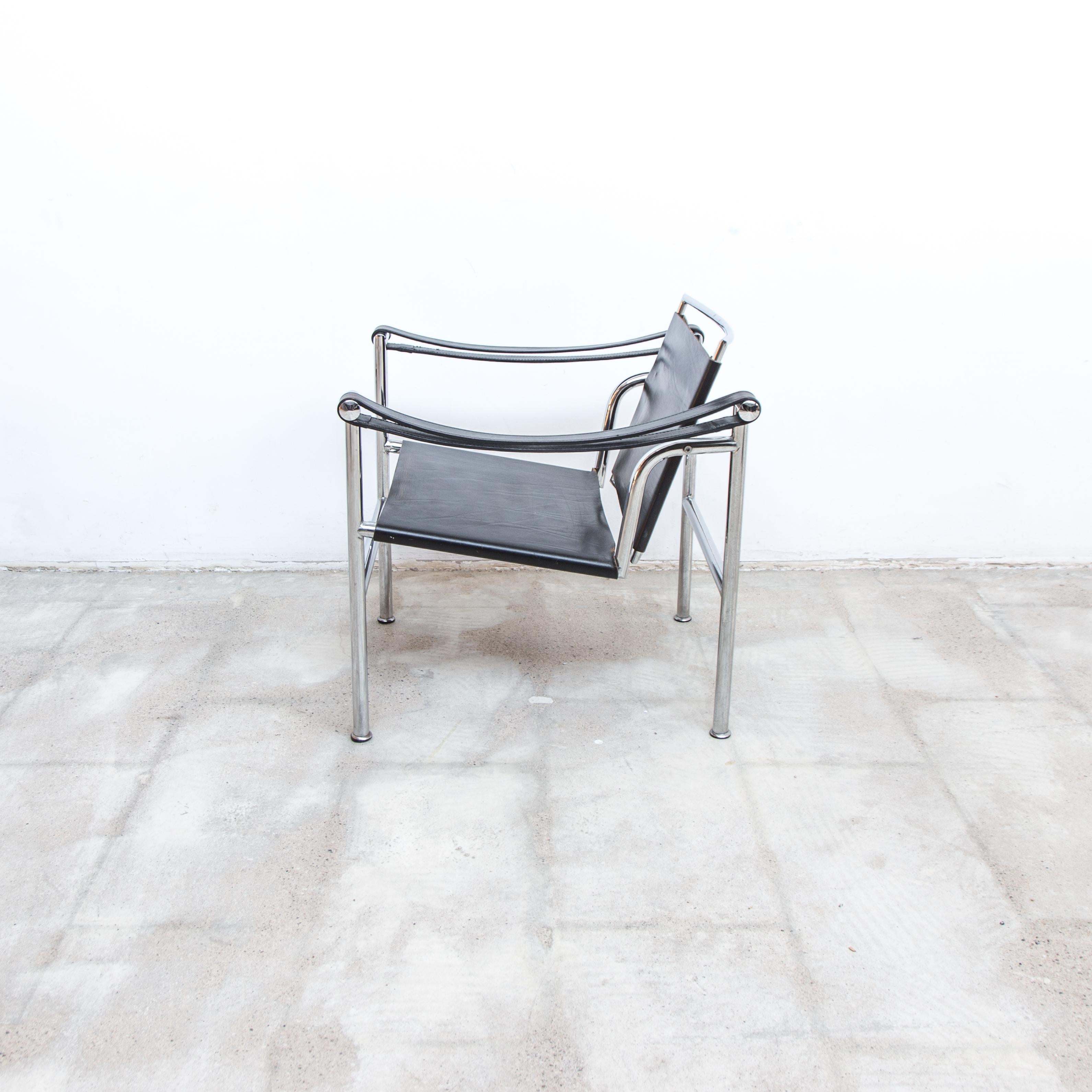 A nicely patinated LC1 sling chair, black leather on chrome frames. The leather elements connected with steel tension springs.
