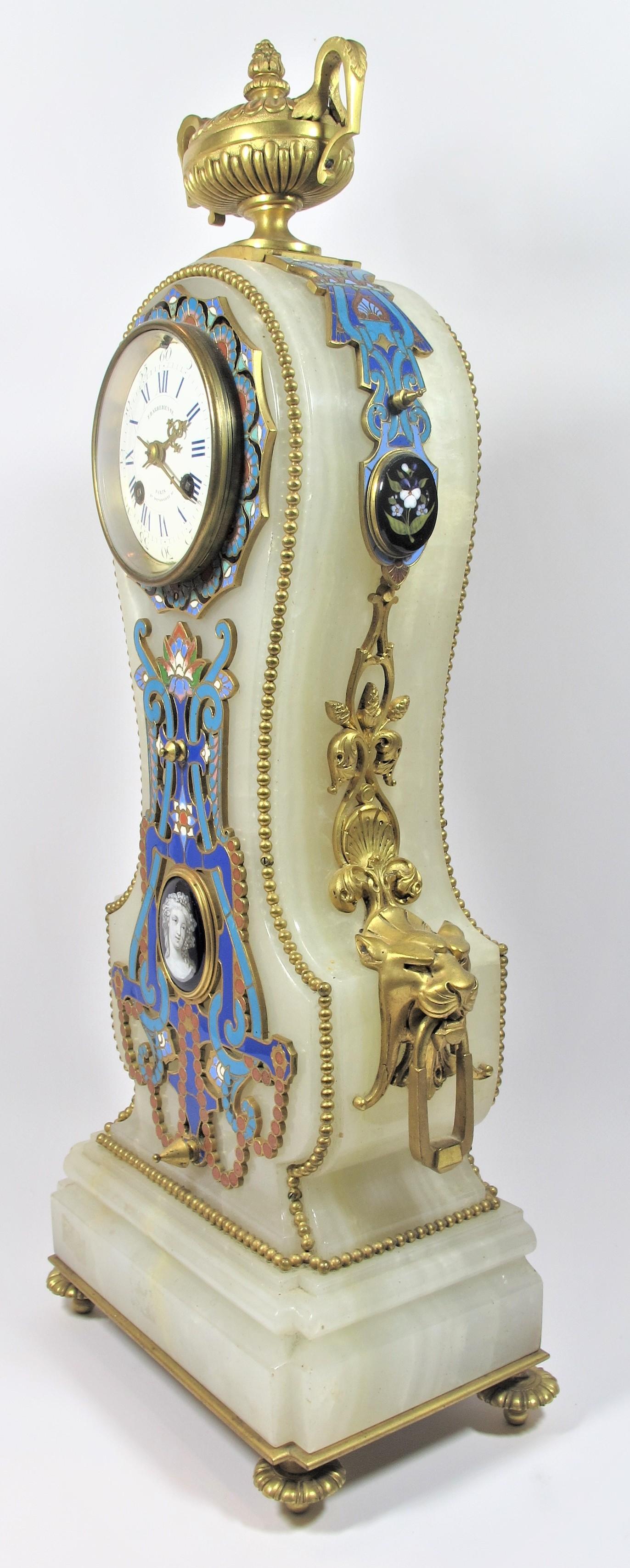 Fireplace set comprising of a clock and two candelabra with four lights, made of onyx, gilded bronze, enamelled plate, cabochons of hard stone marquetry, and champlevés enamels polychrome. The style of this splendid set is characteristic of the most