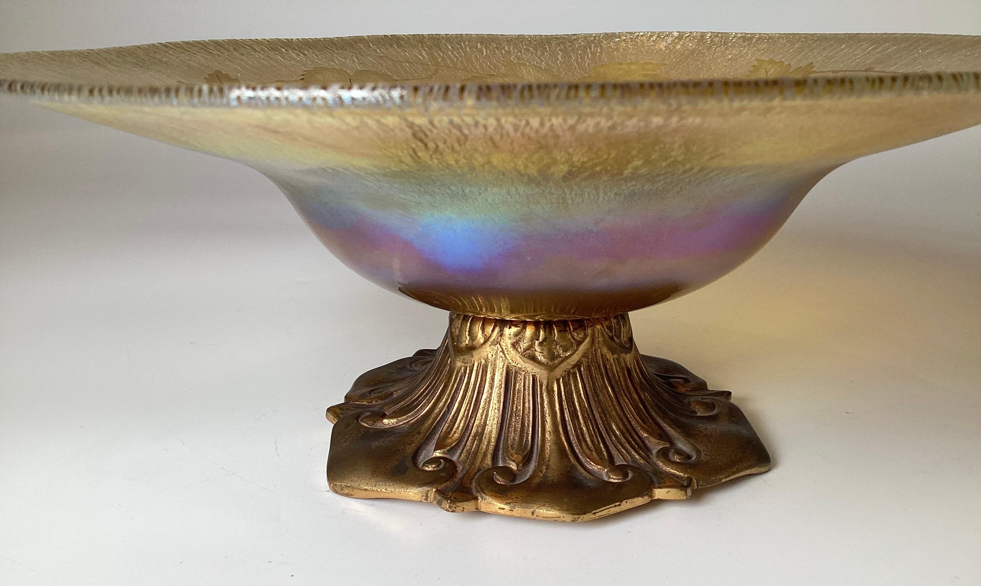 Coupe à soleil gravée en creux avec feuille et vigne Faville irisée au centre
Sur un socle signé en bronze
La base est signée A.I.C. Tiffany Surfaces