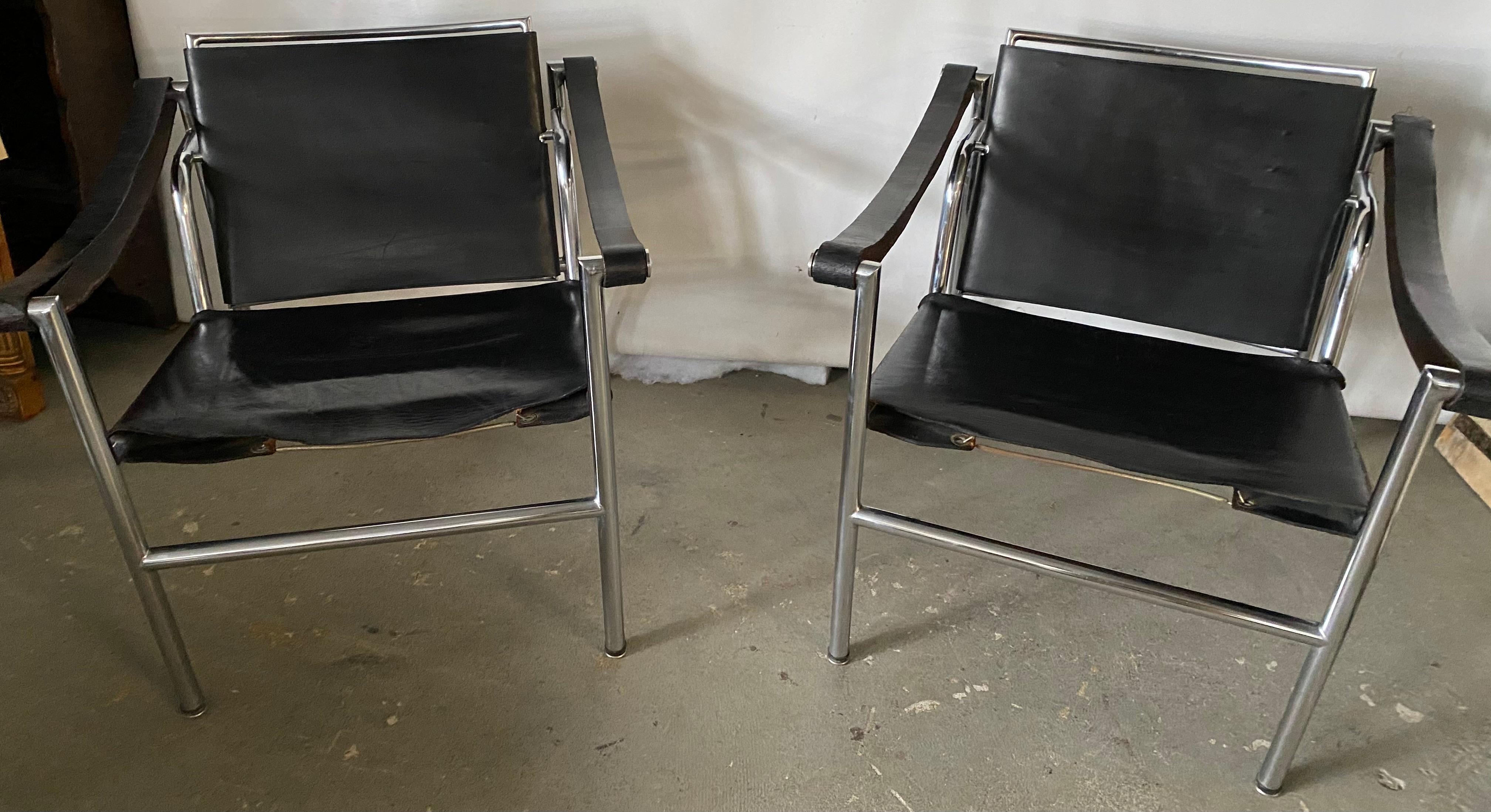 The LC1 style occasional lounging arm chairs with leather and springs straps and chrome frame are in very good condition. These are not marked but could possibly be LC1 chairs since there was a period when these chairs were manufactured but not