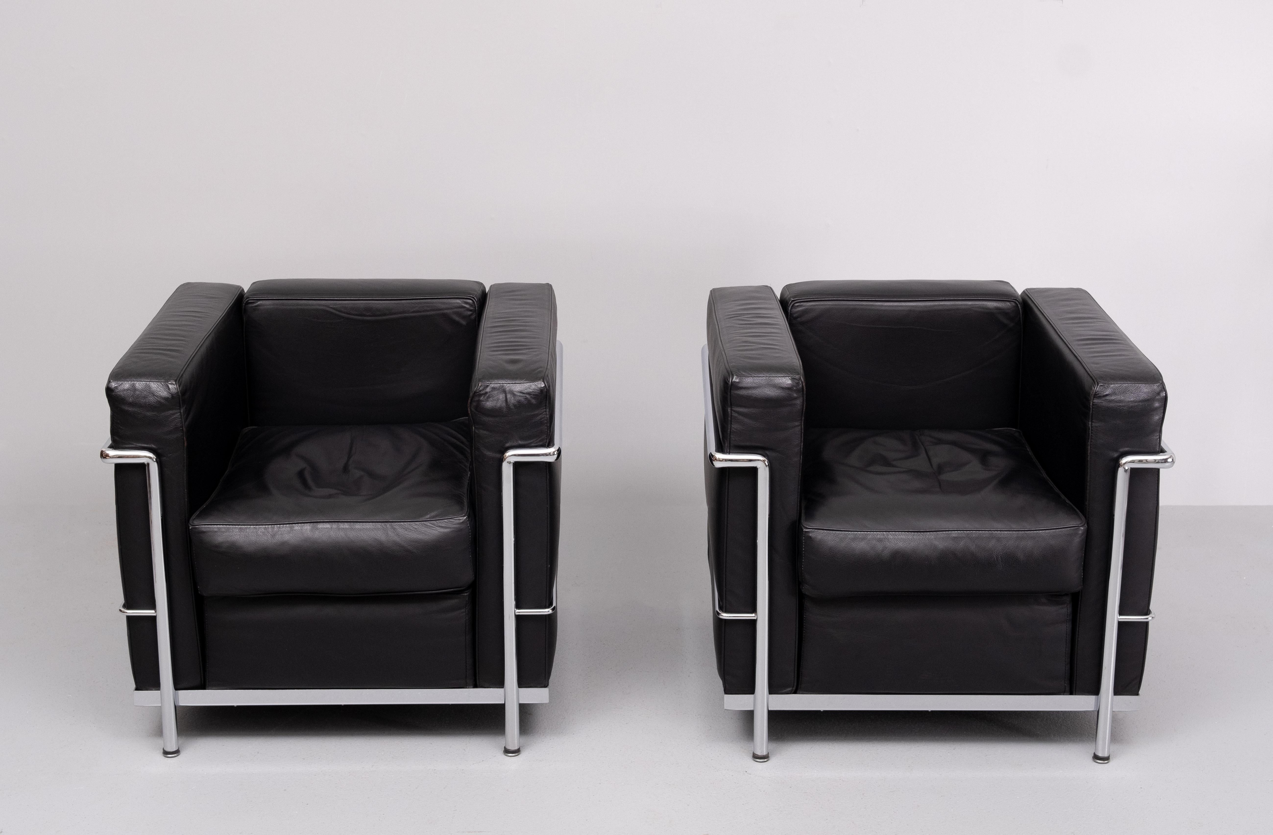 Belle paire de  Fauteuils LC2 de Le Corbusier en cuir noir 
rembourrage . Sur un cadre en acier chromé. Fabriqué par Alivar 
Italie années 1990 . Chaises de très bonne qualité. Livré avec juste la bonne quantité 
de patine . Bon confort d'assise .
