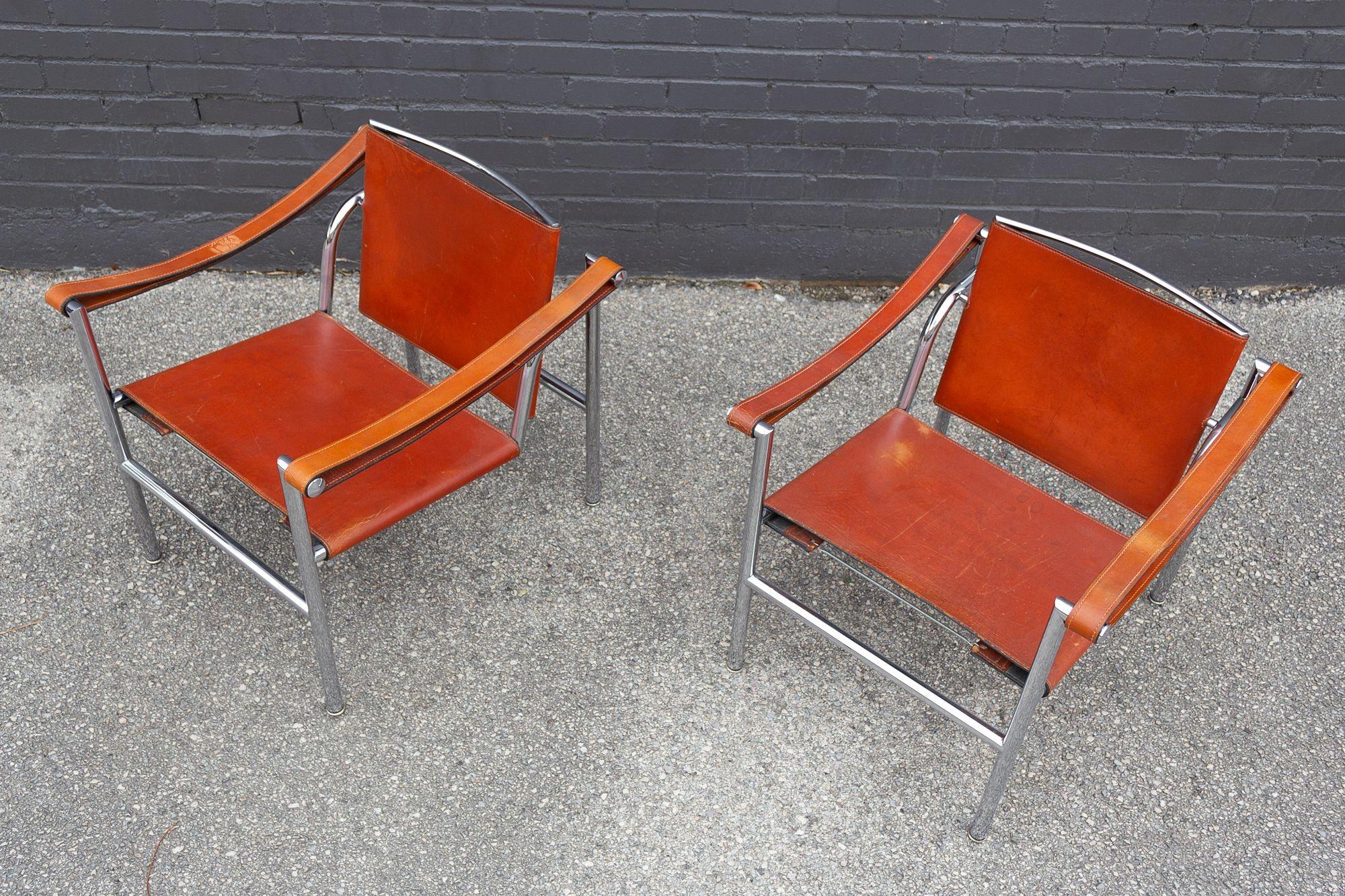 Vintage pair of LC2 tilt-back lounge chairs produced by Cassina in the less commonly seen cognac leather. Nicely broken in with all the patina you need to add a little comfort and sophistication to your living room.